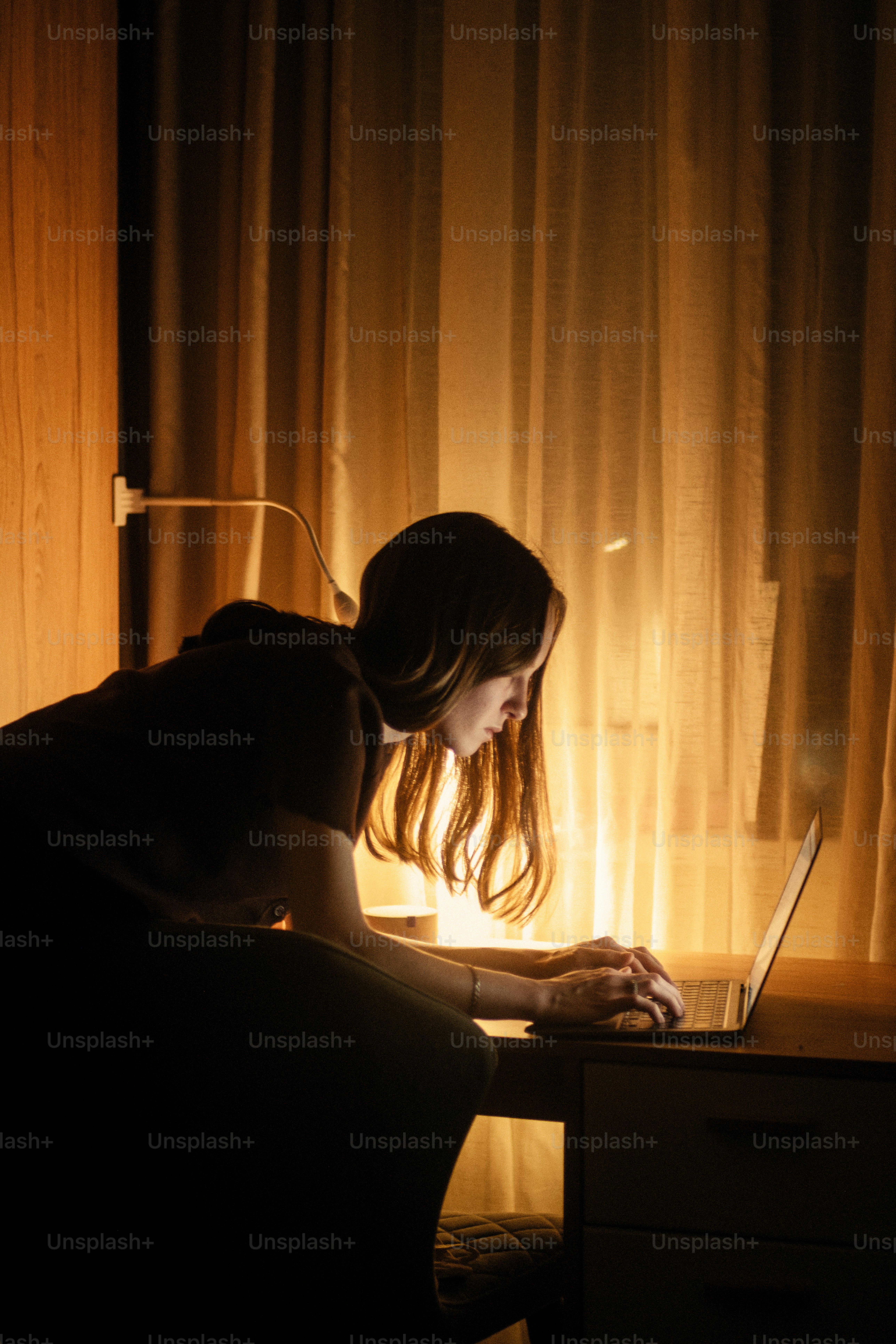 Junge Frau, die nachts am Laptop arbeitet.