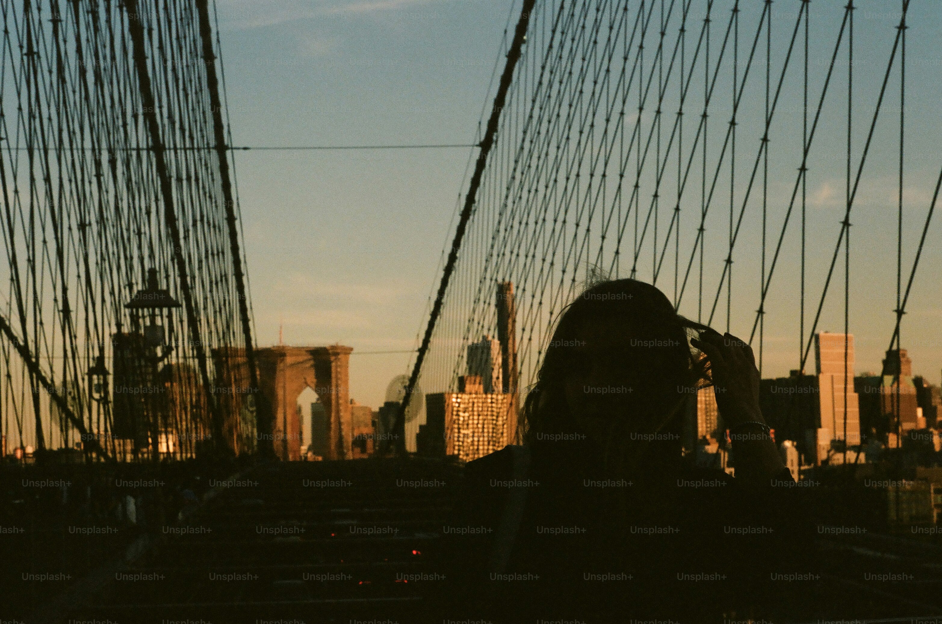 Silhouette of a person on a bridge at sunset