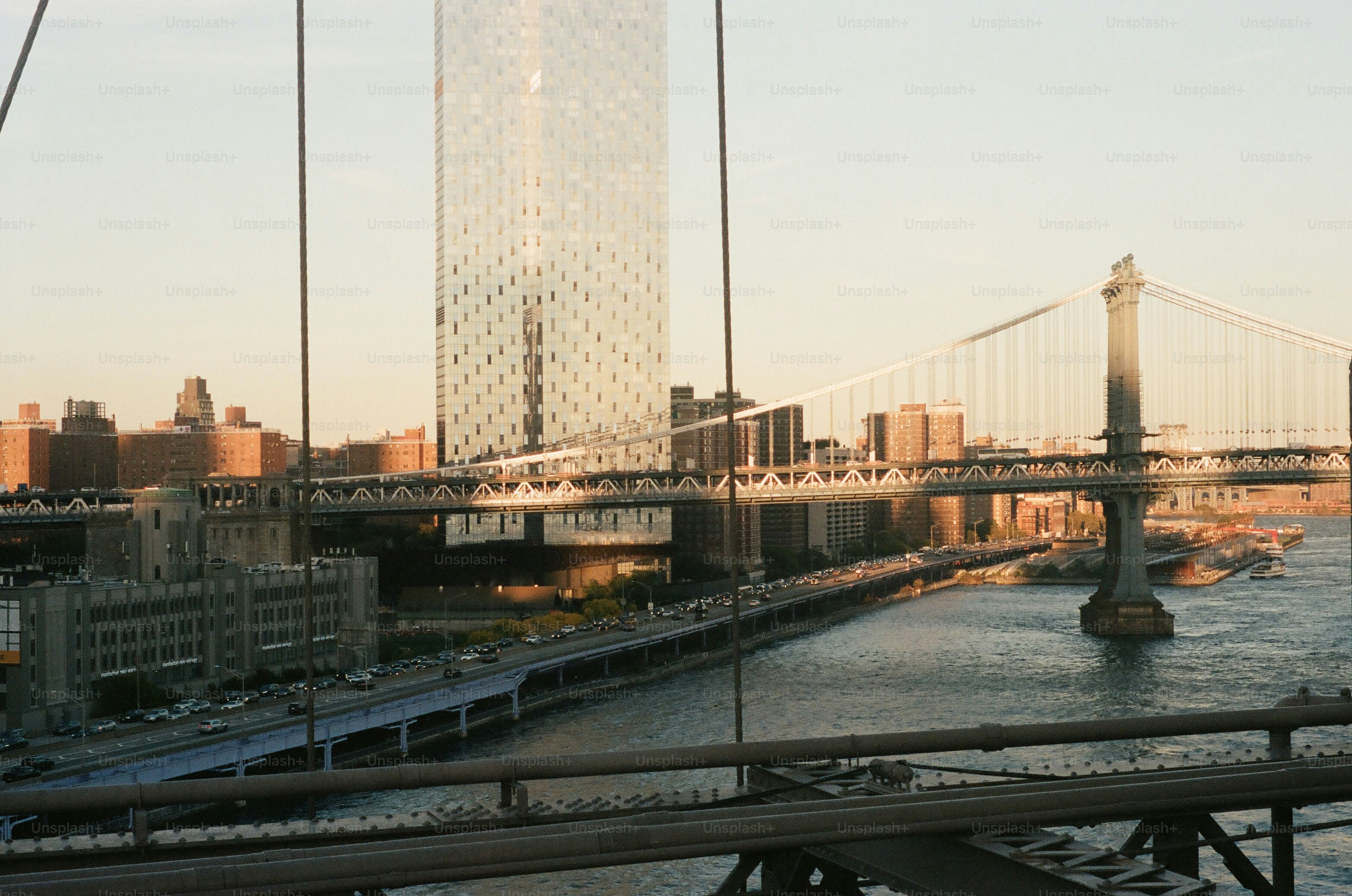 Modern skyscraper and suspension bridge over river