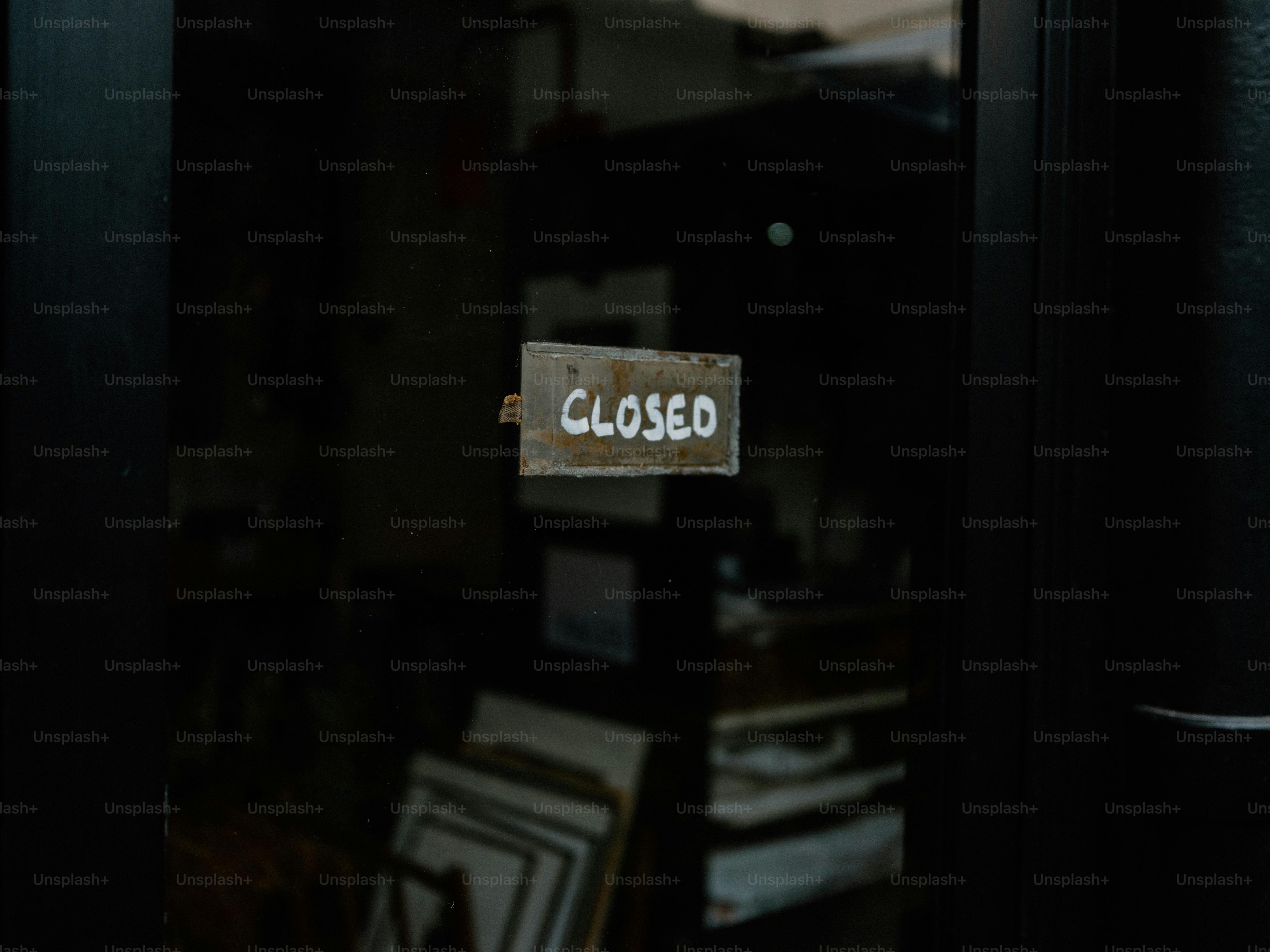 A weathered sign reads closed on a glass door.