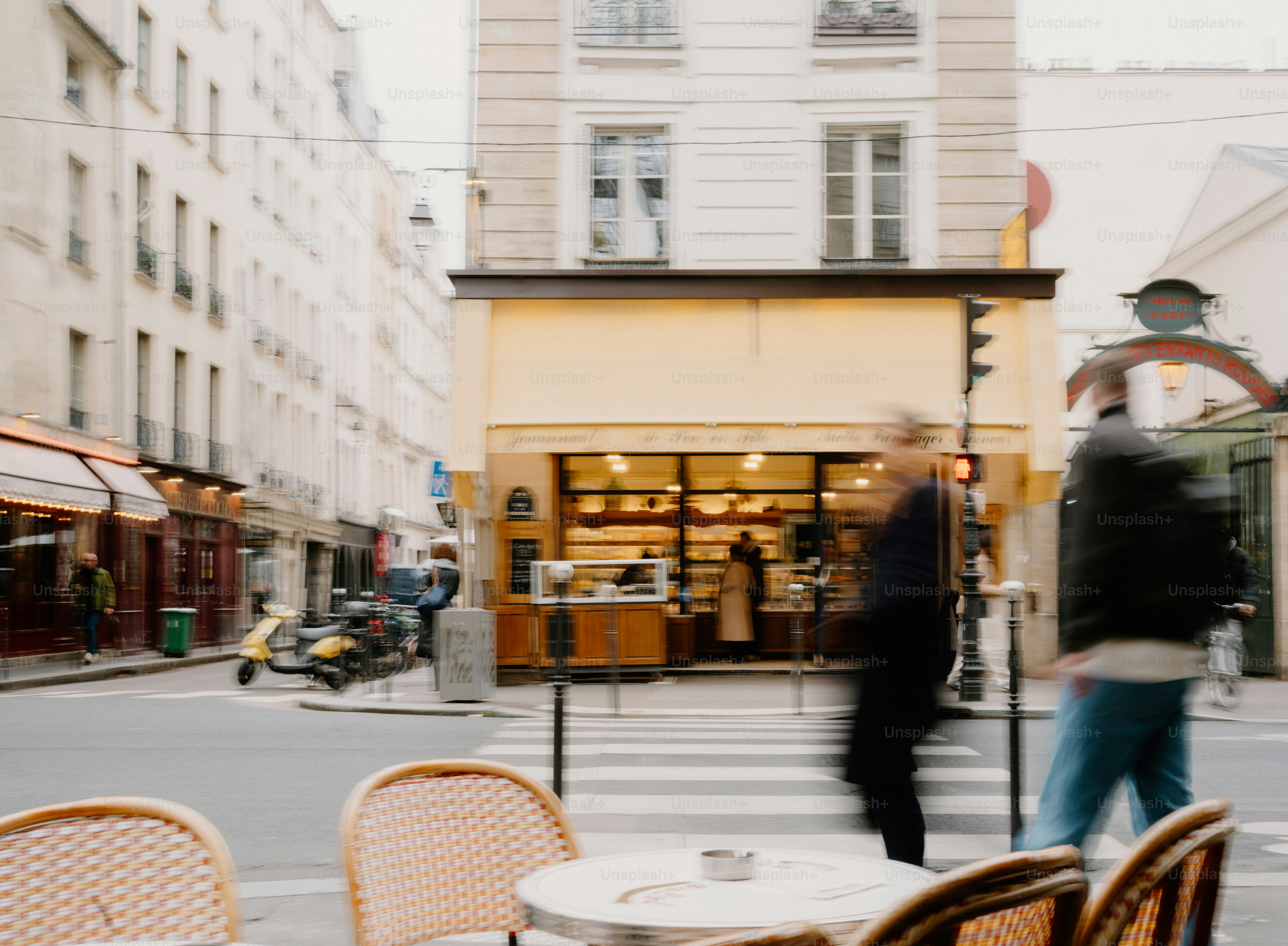 Menschen, die an einer Bäckerei in einer Pariser Straße vorbeigehen.