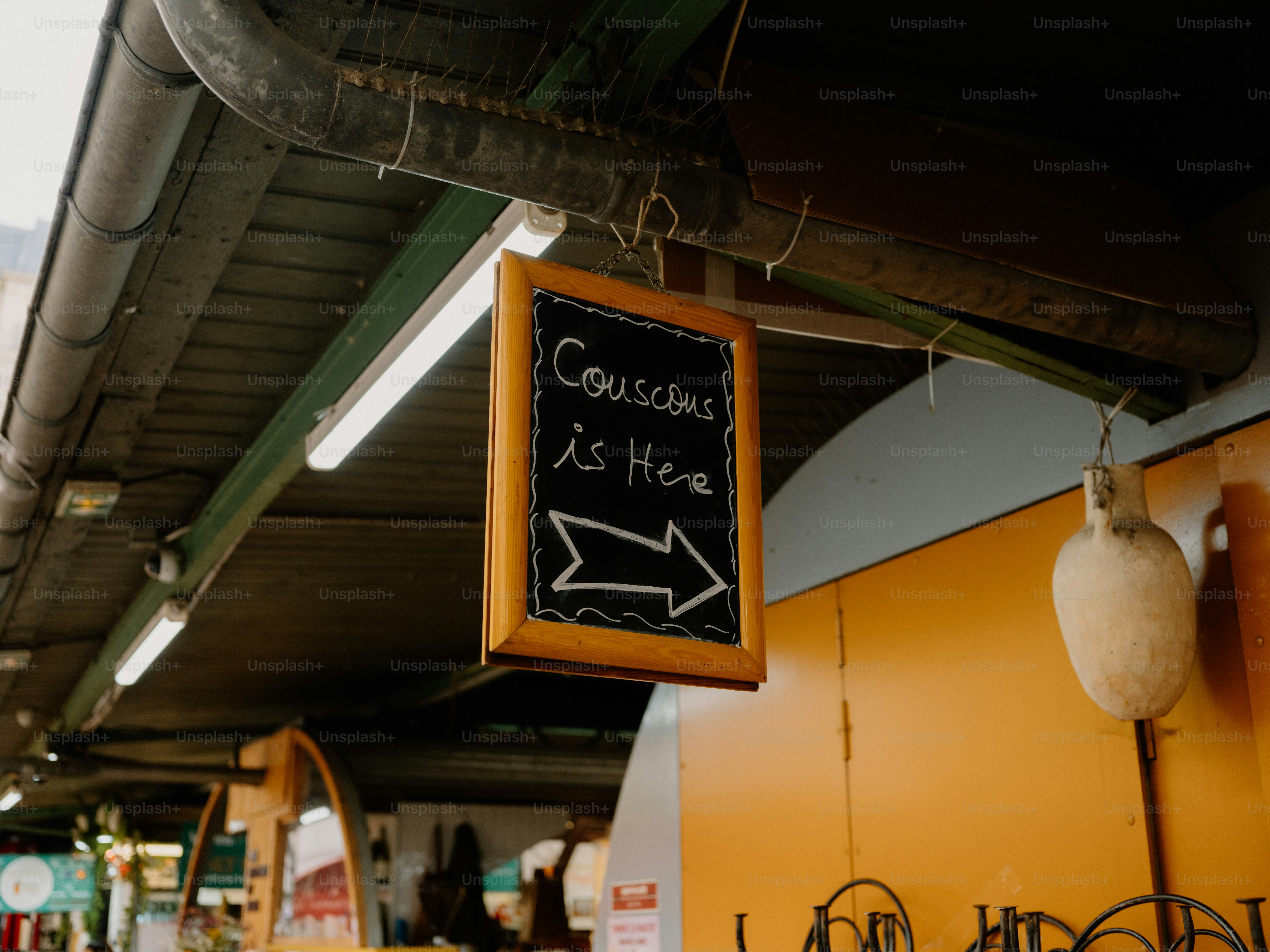 Chalkboard sign indicating couscous is here with an arrow