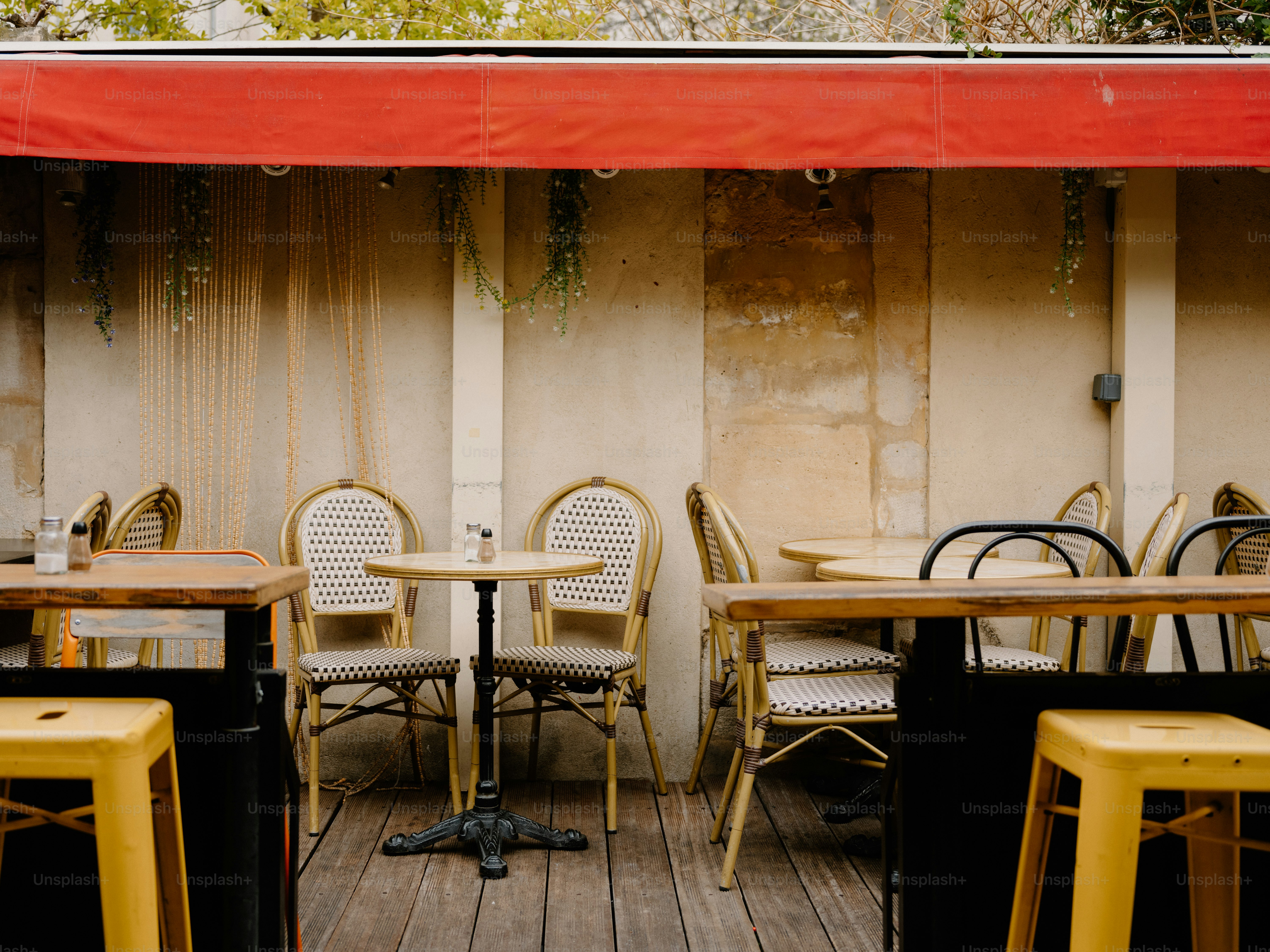 Empty outdoor cafe seating with red awning.
