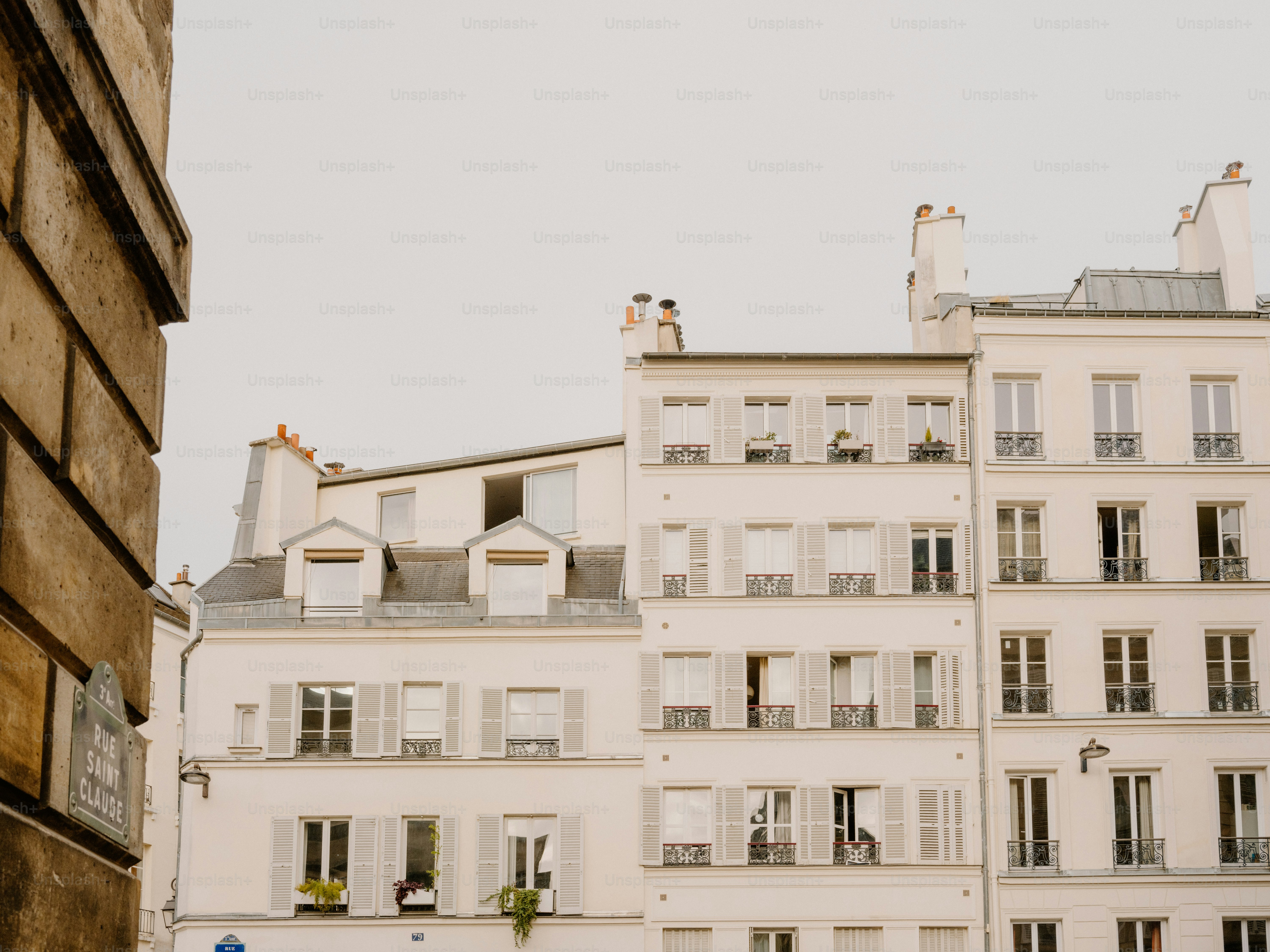 Bangunan putih dengan daun jendela di bawah langit pucat