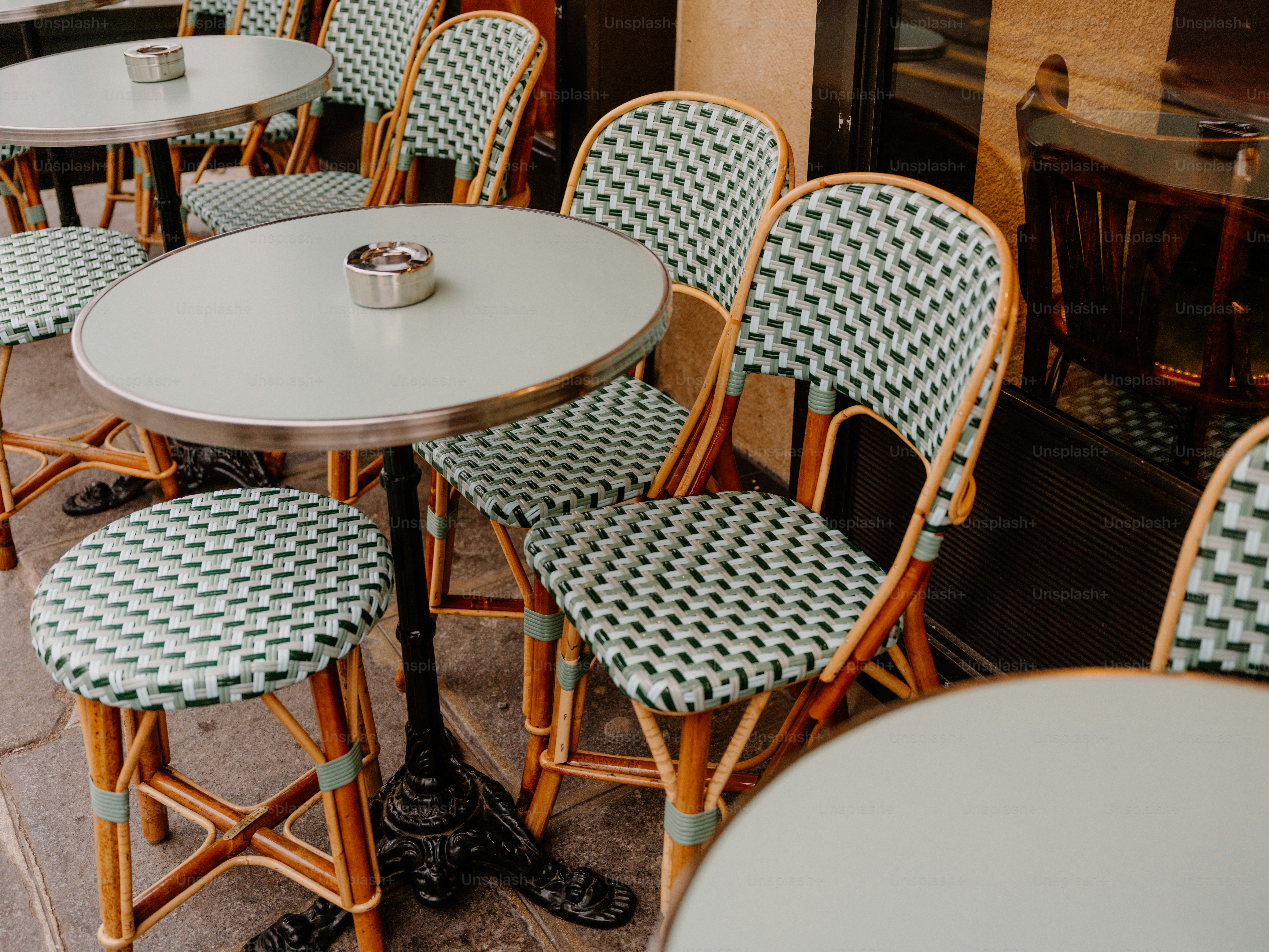 Outdoor cafe tables and chairs with woven seats
