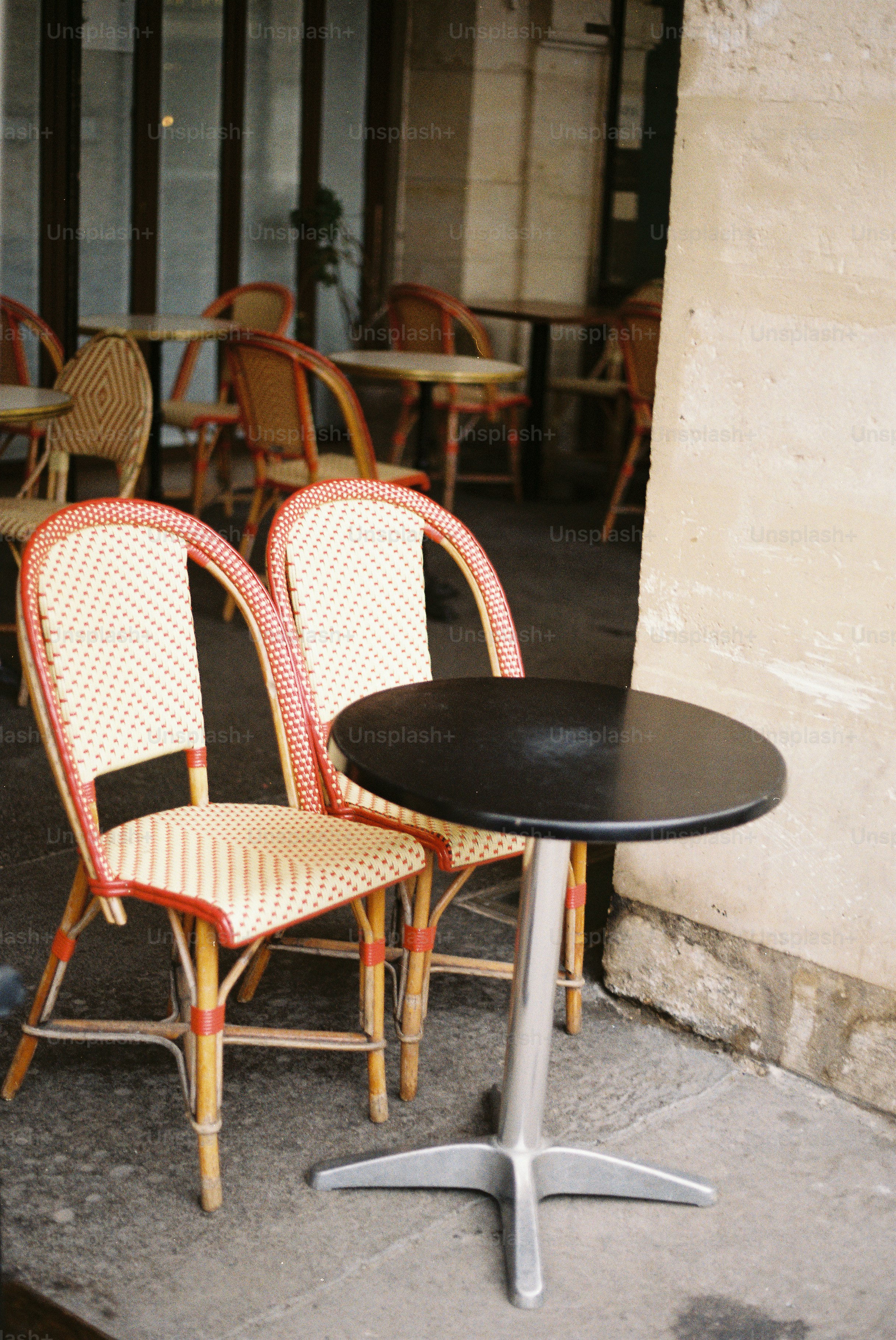Two wicker chairs beside a small cafe table