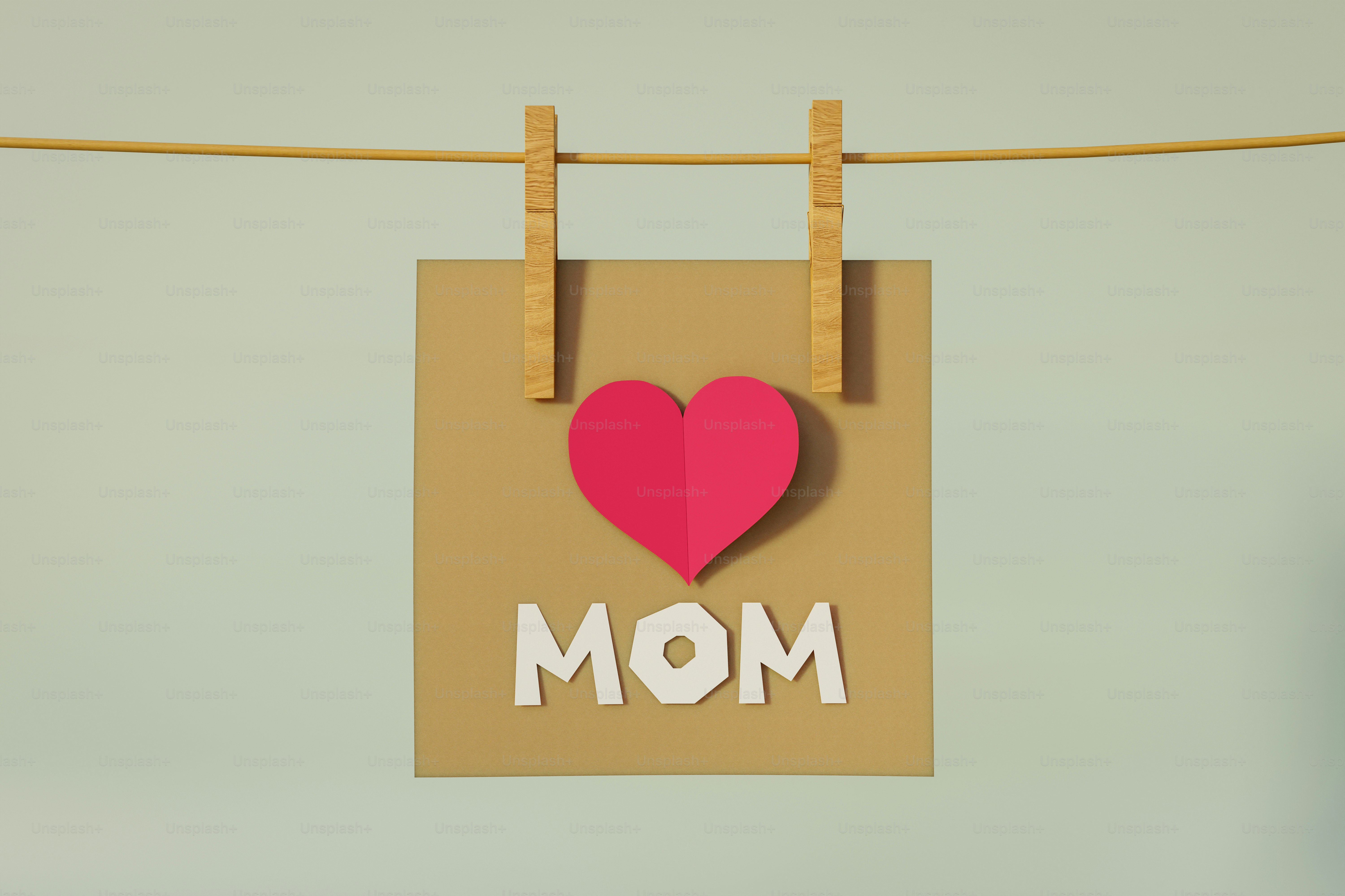Tarjeta con corazón y texto de "mamá" colgado en tendedera.
