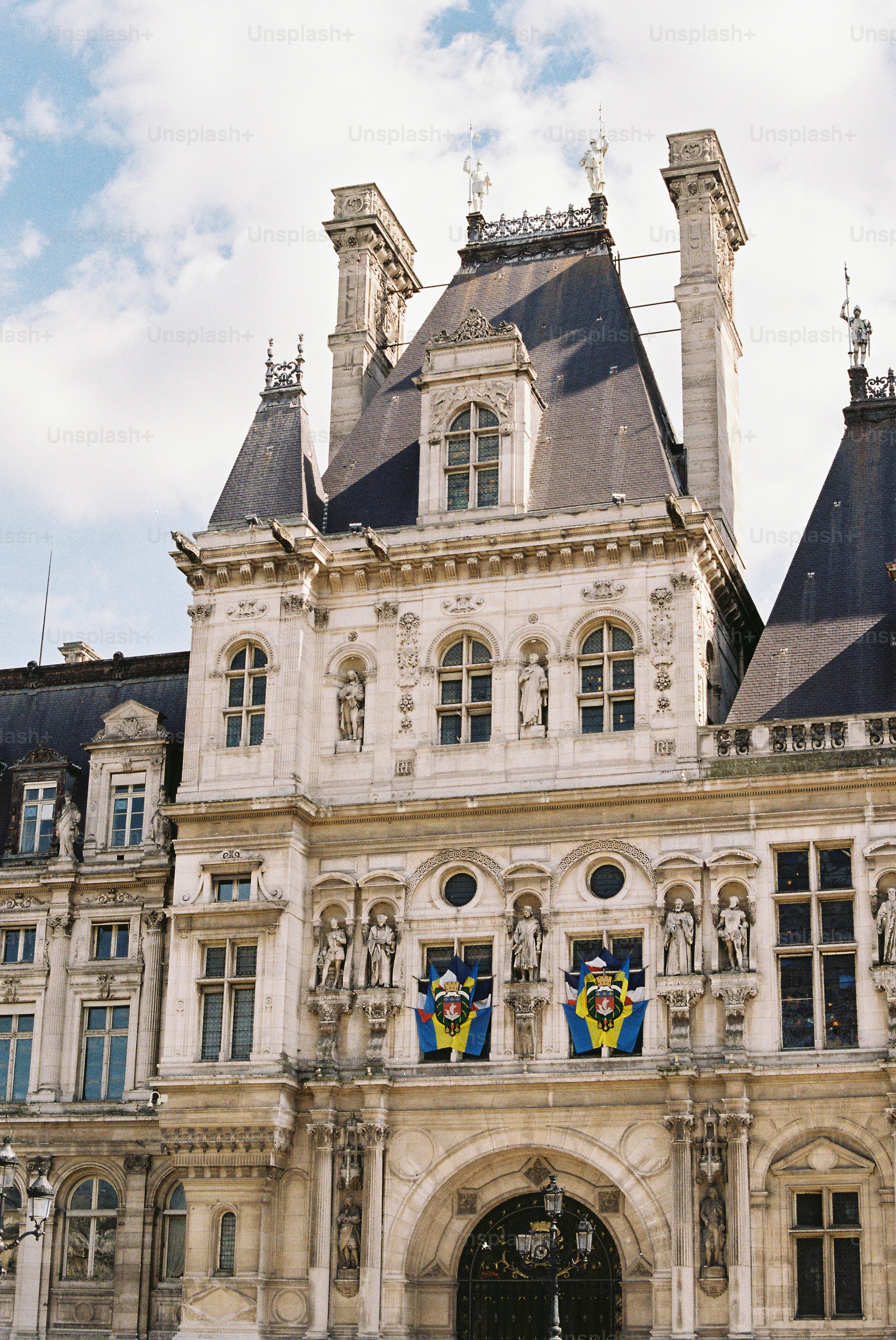 Fachada ornamentada de un edificio histórico con banderas.