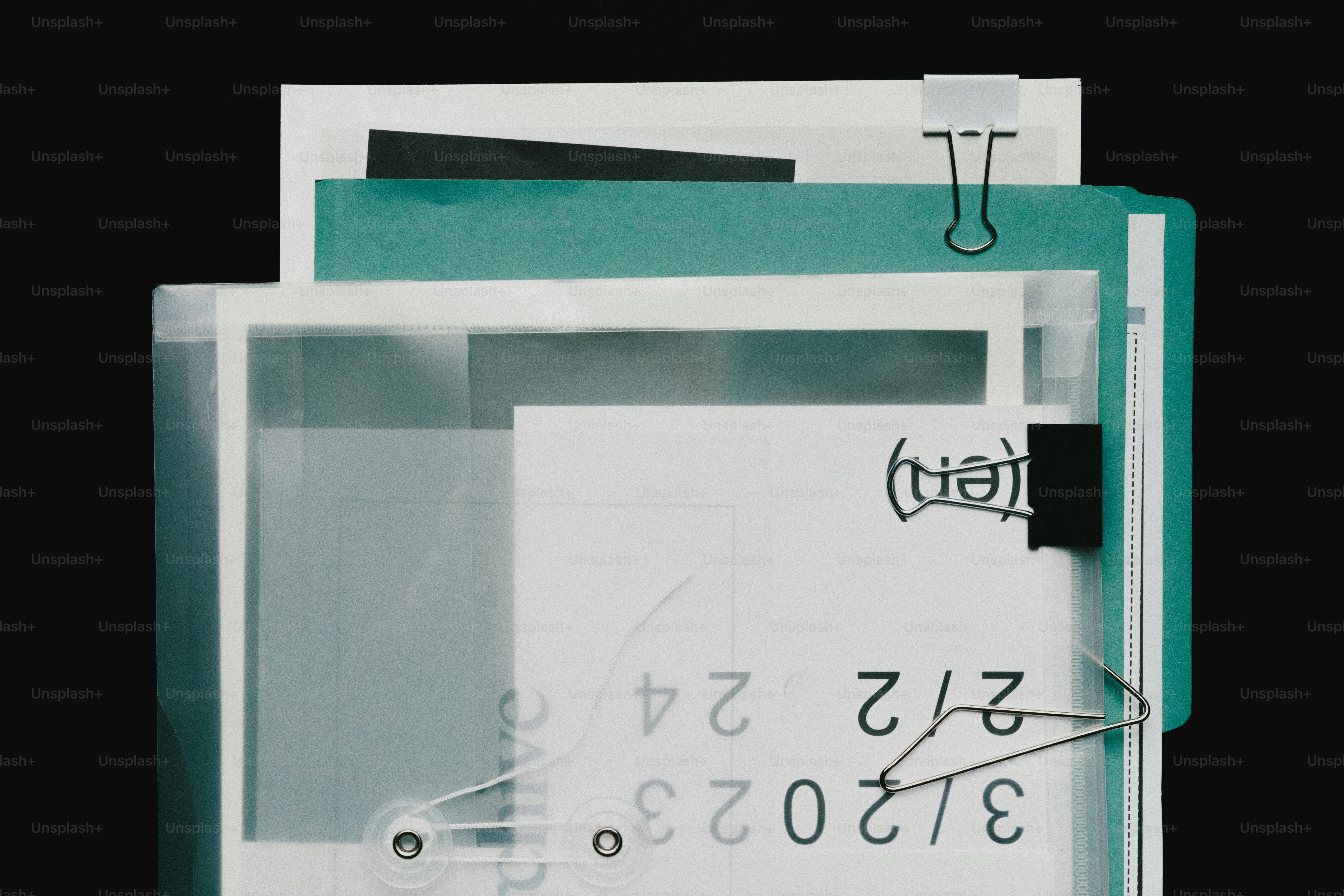 Pilha de papéis com clipes de pasta sobre fundo preto