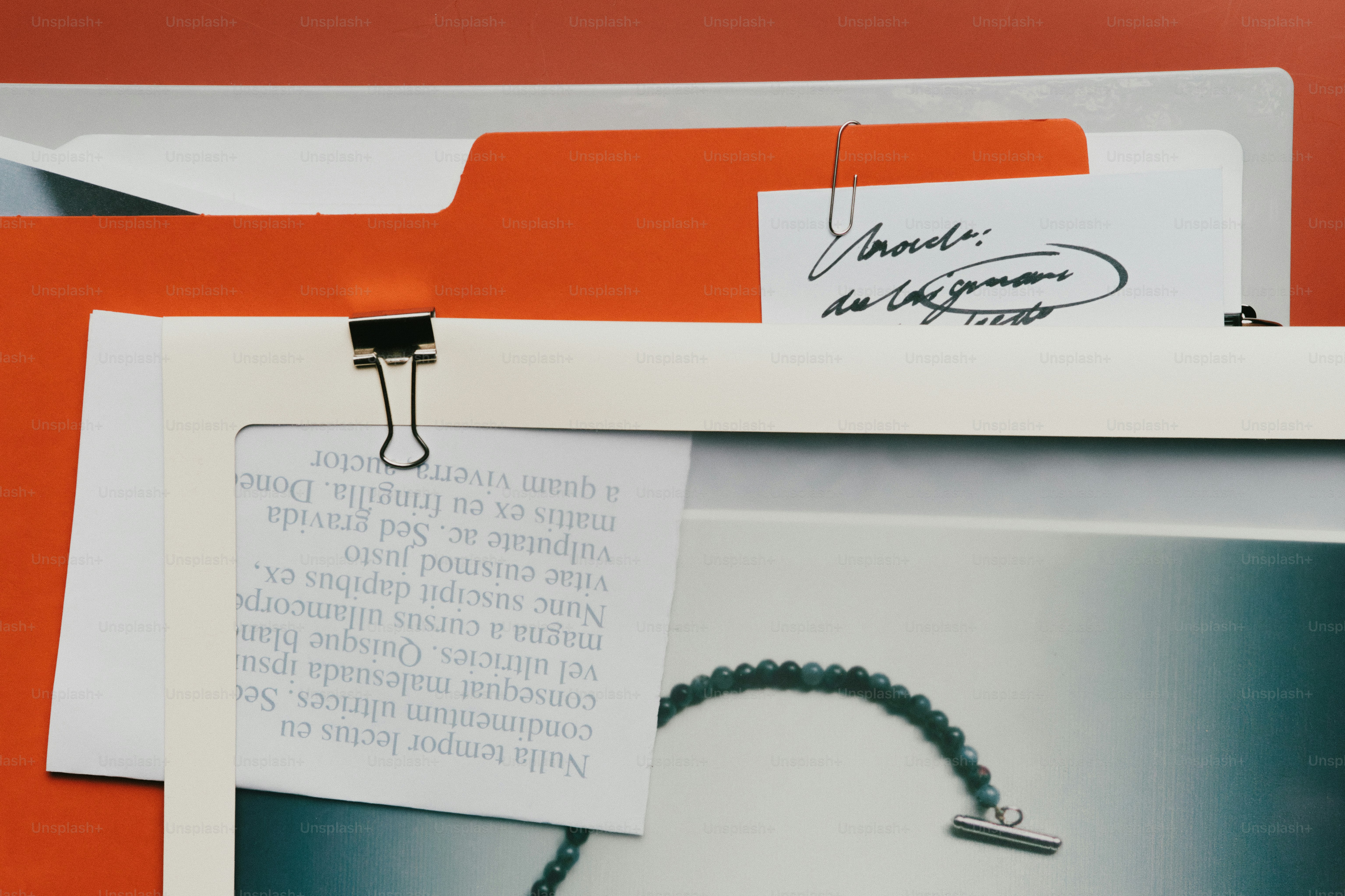 Pastas laranja com papéis e um clipe de pasta