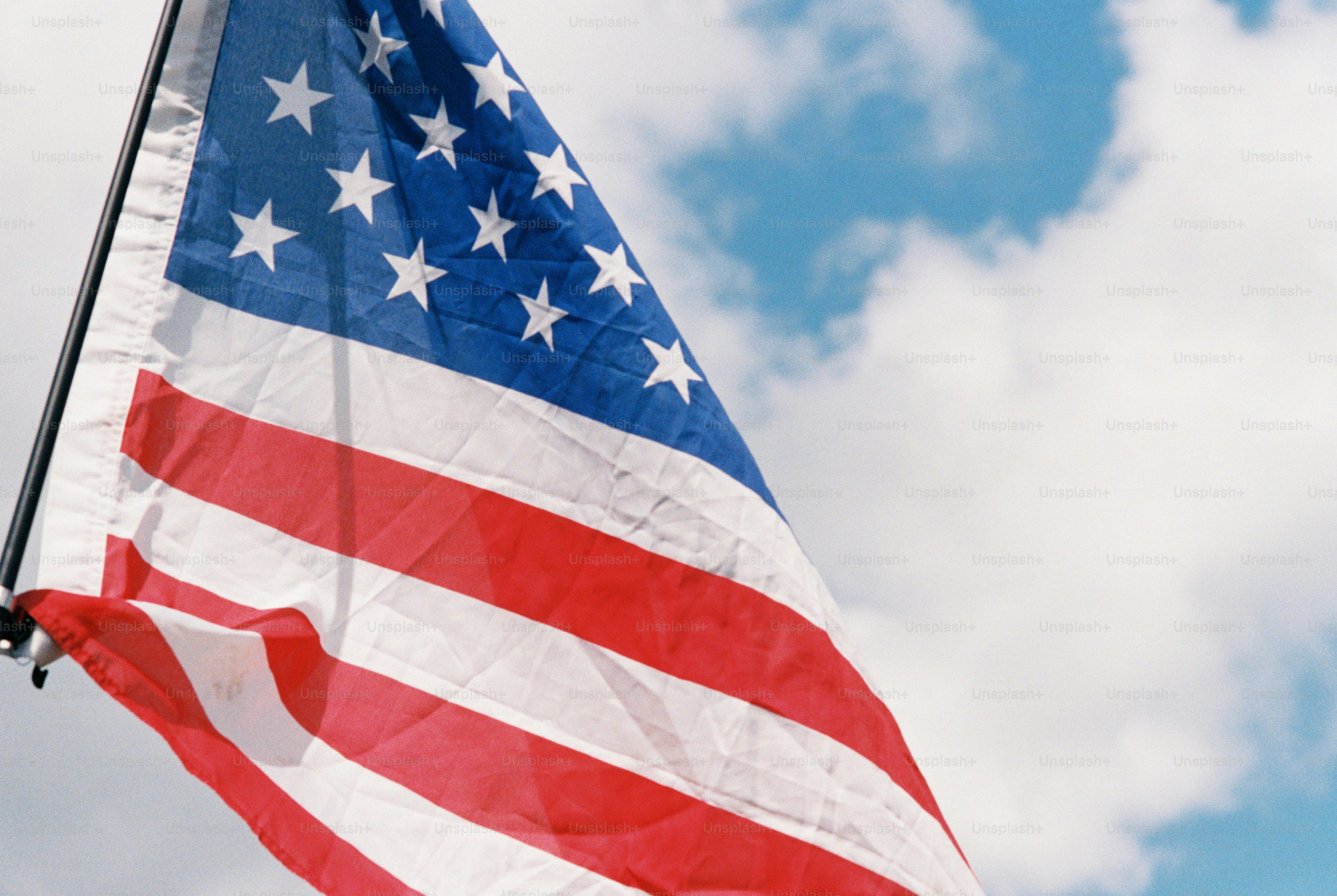 흐린 푸른 하늘 위로 펄럭이는 미국 국기