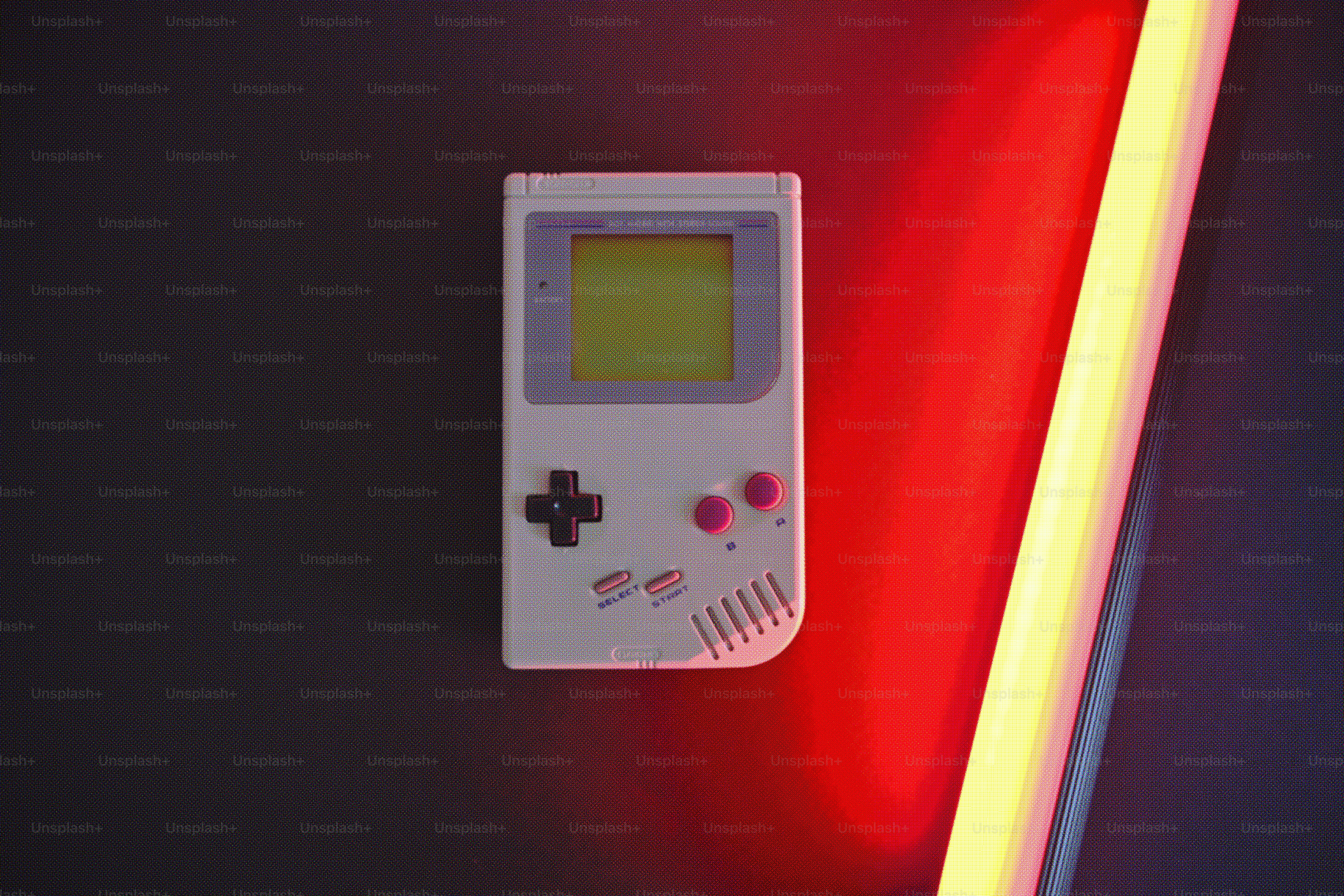 Game boy vintage putih dengan lampu neon merah.