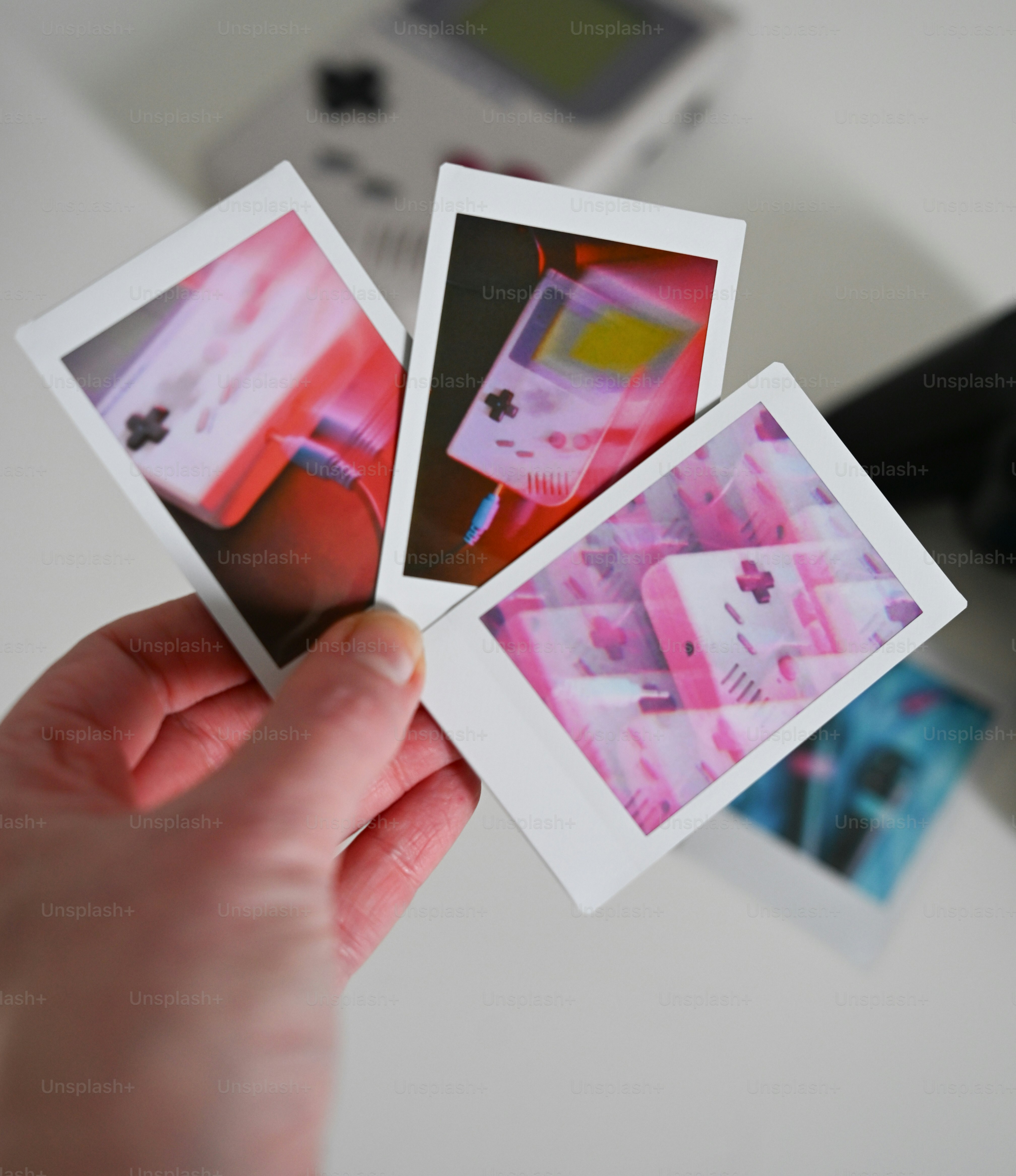 Tangan memegang foto instan konsol game retro