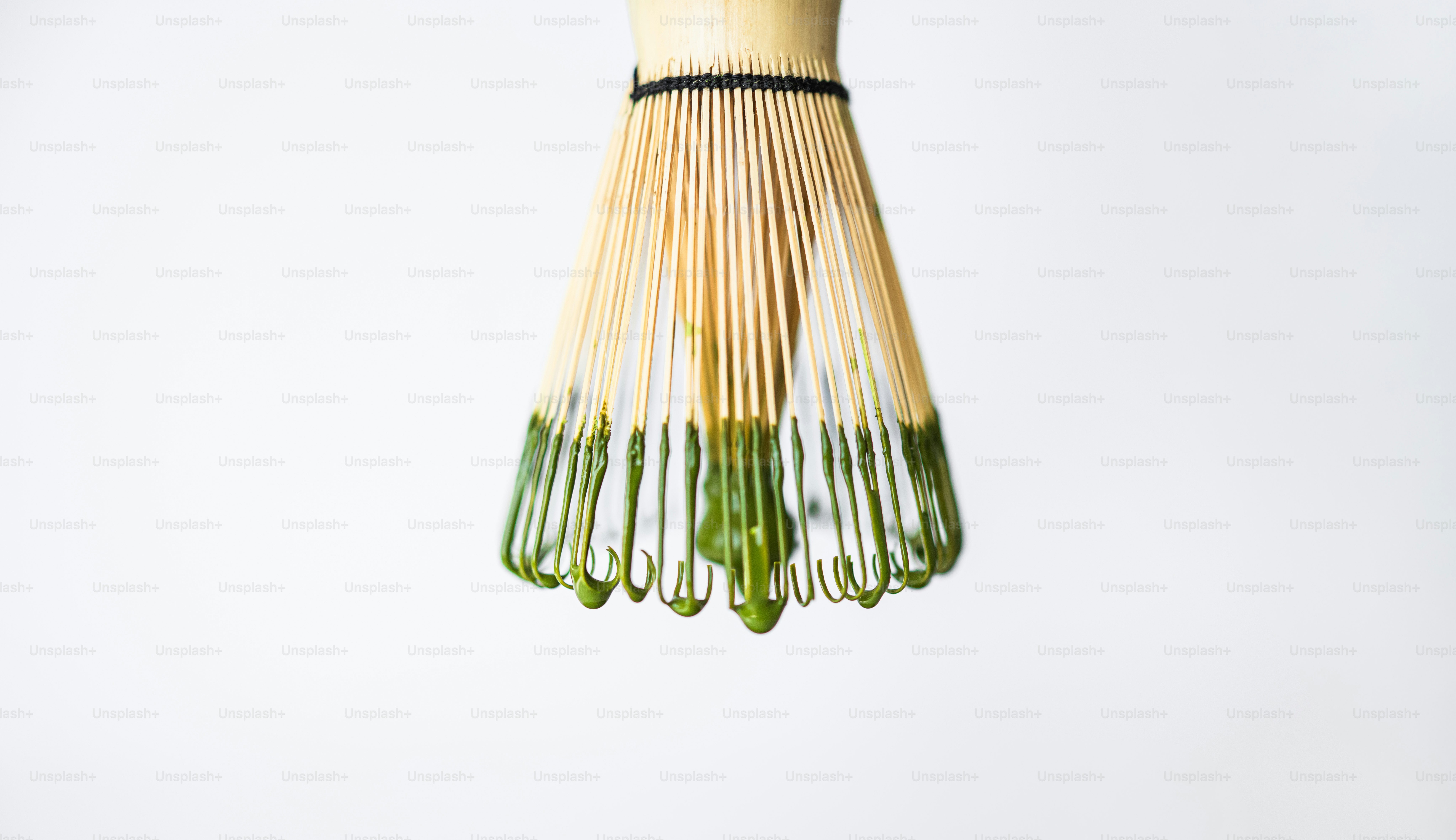 Bamboo whisk with green matcha tea residue