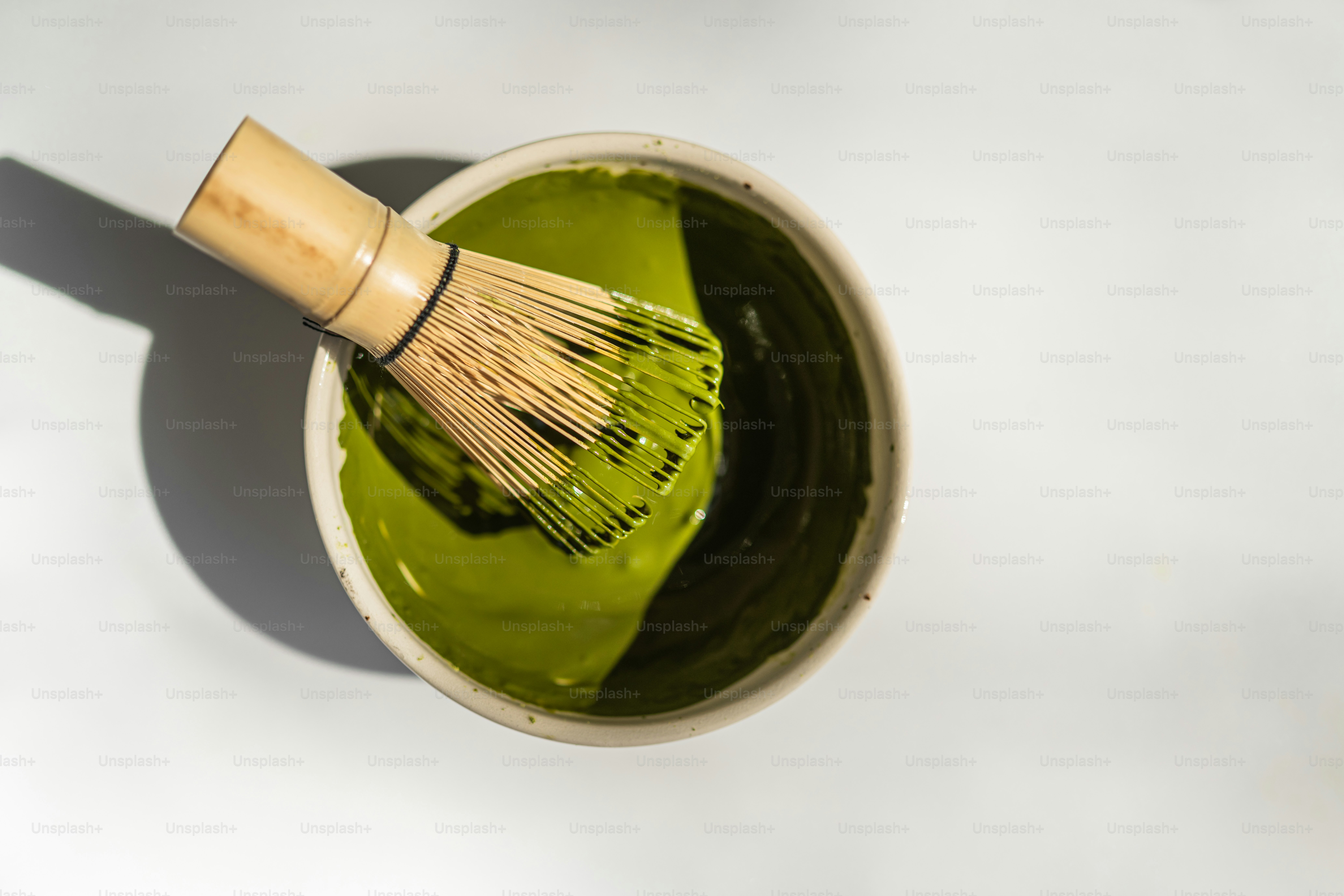 Bamboo whisk in a bowl of matcha tea