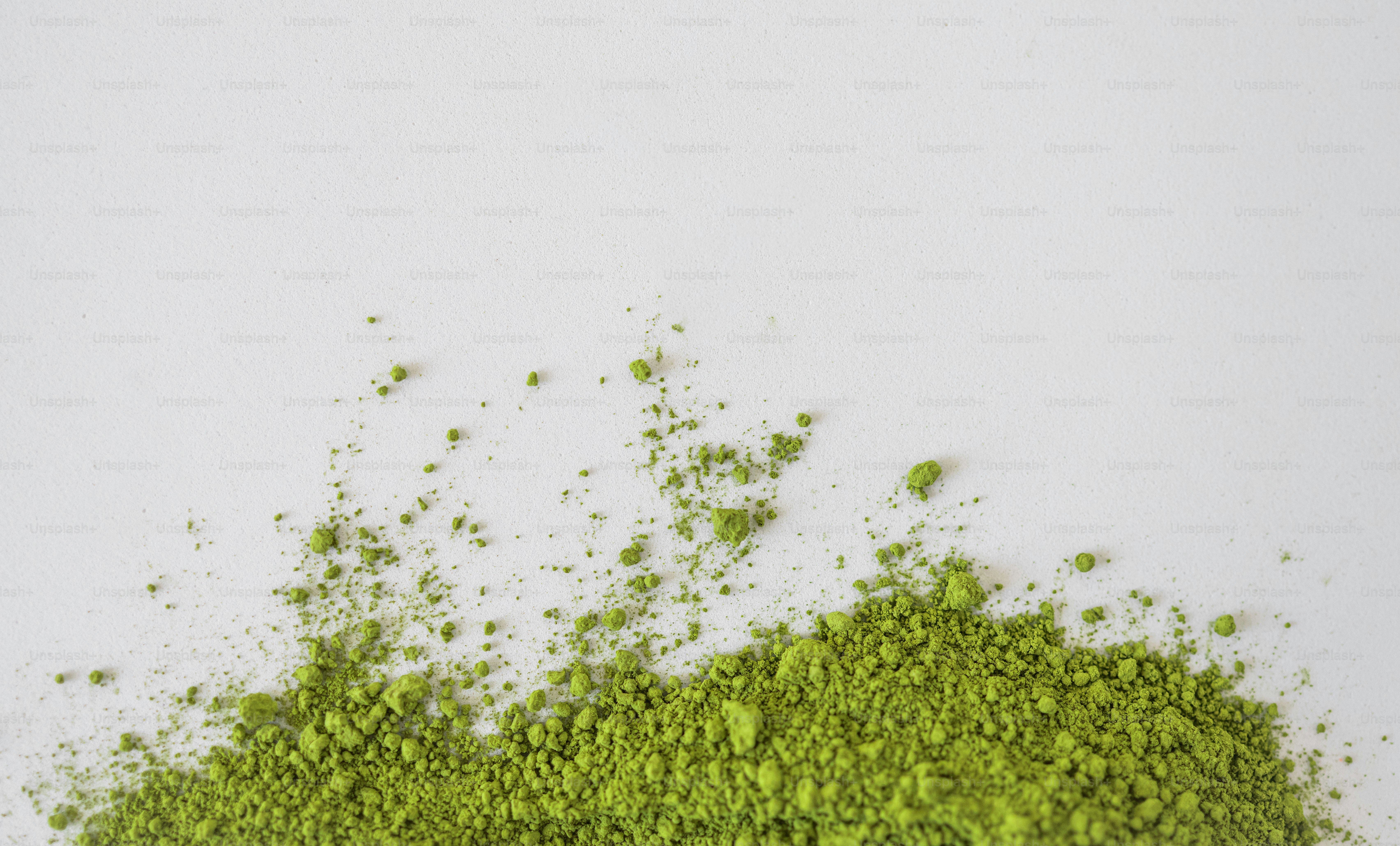 A pile of green matcha powder on a white surface. photo – Matcha Image ...