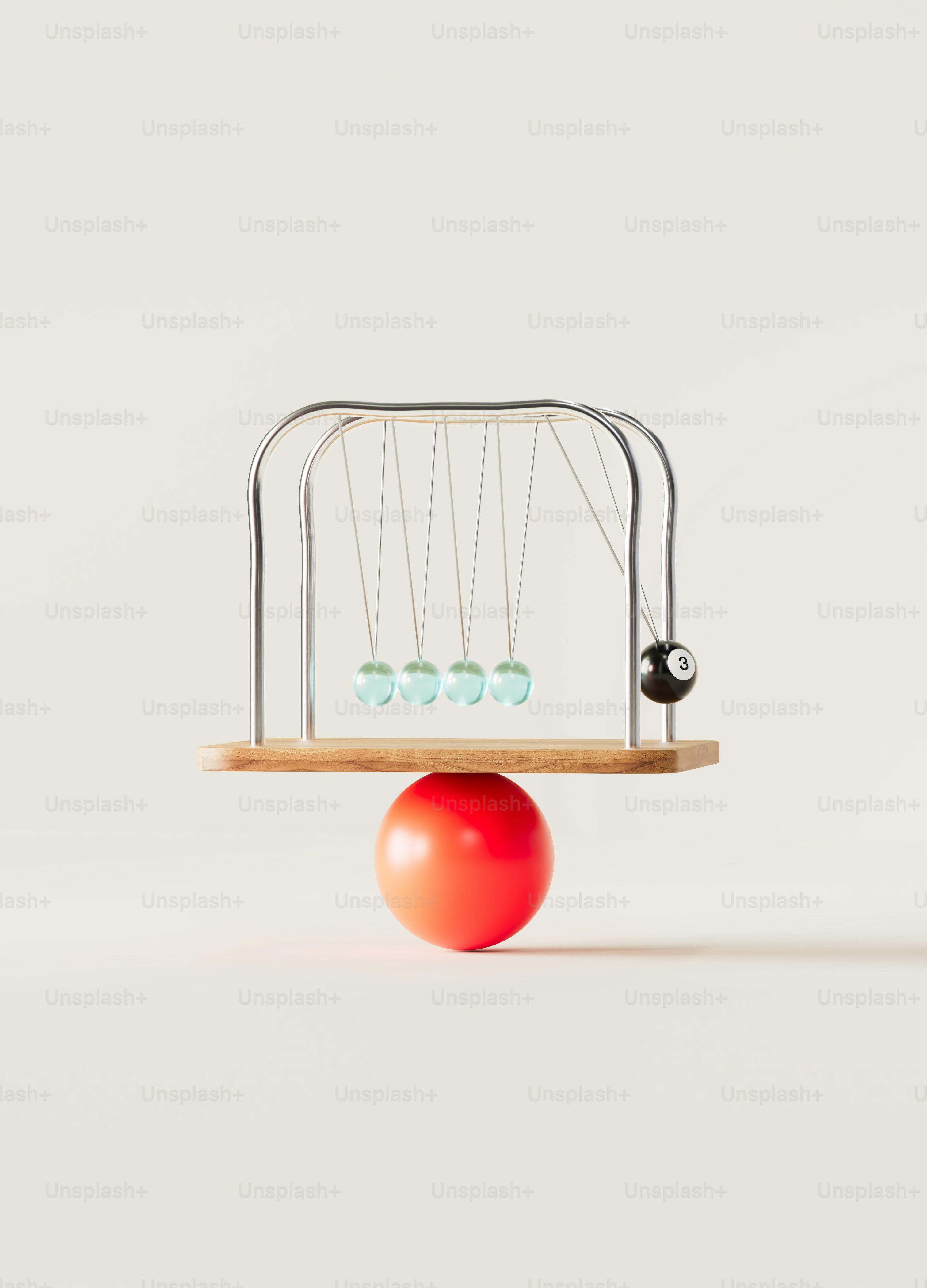 Newton's cradle balanced on a red ball