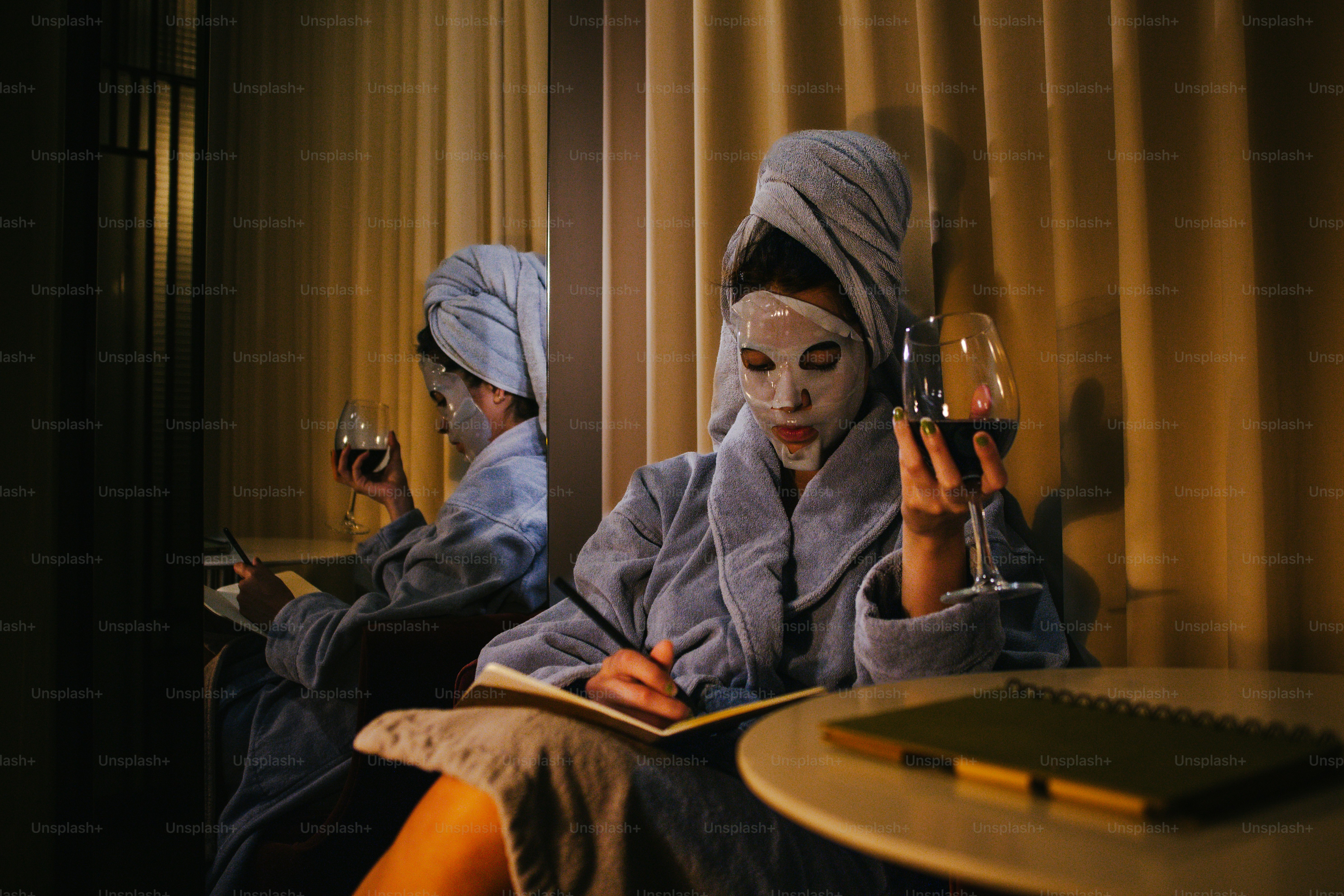 Donna con la maschera beve vino e scrive