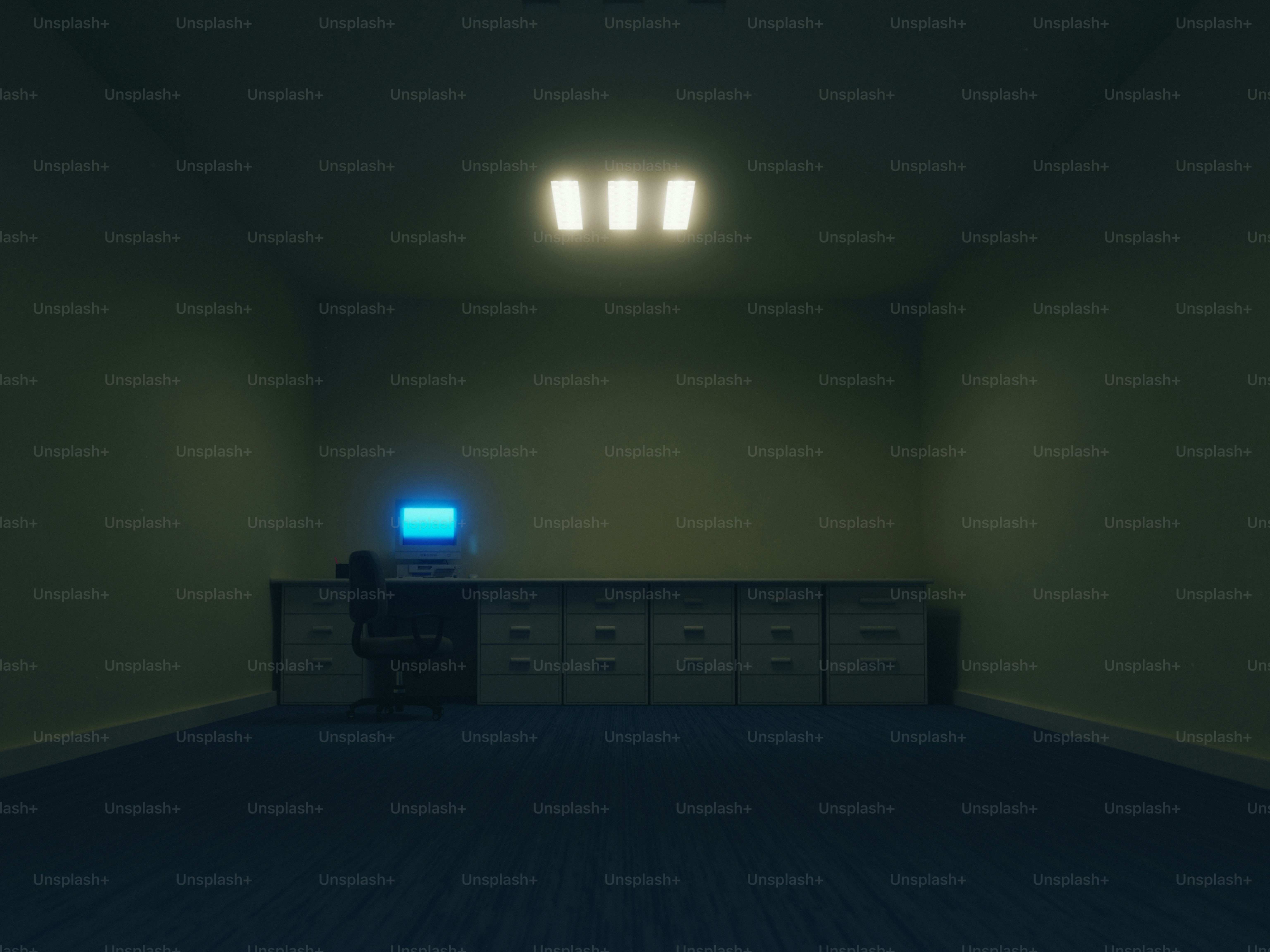 A dimly lit office with a computer on a desk.