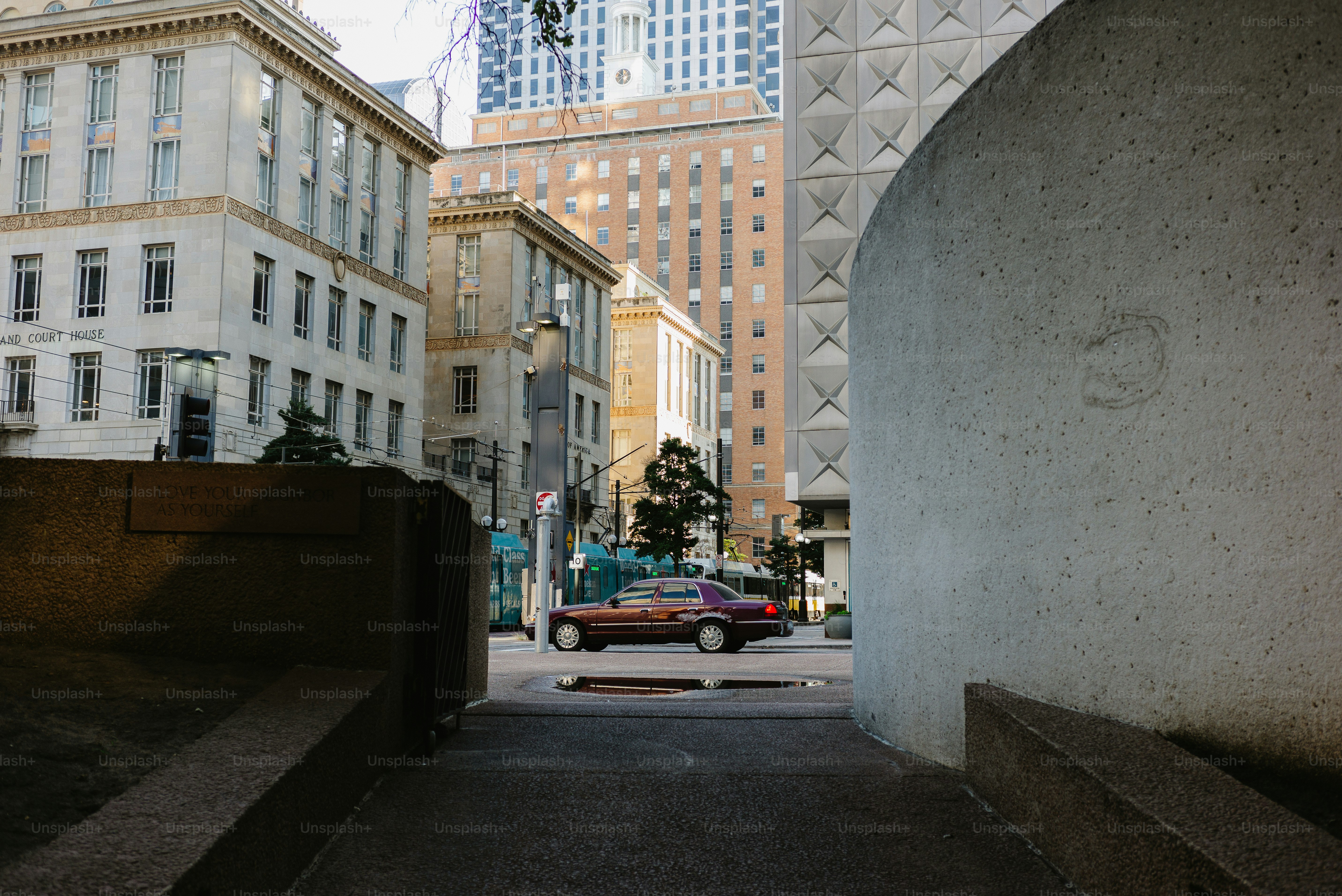 Sebuah mobil diparkir di antara gedung-gedung di sebuah kota.