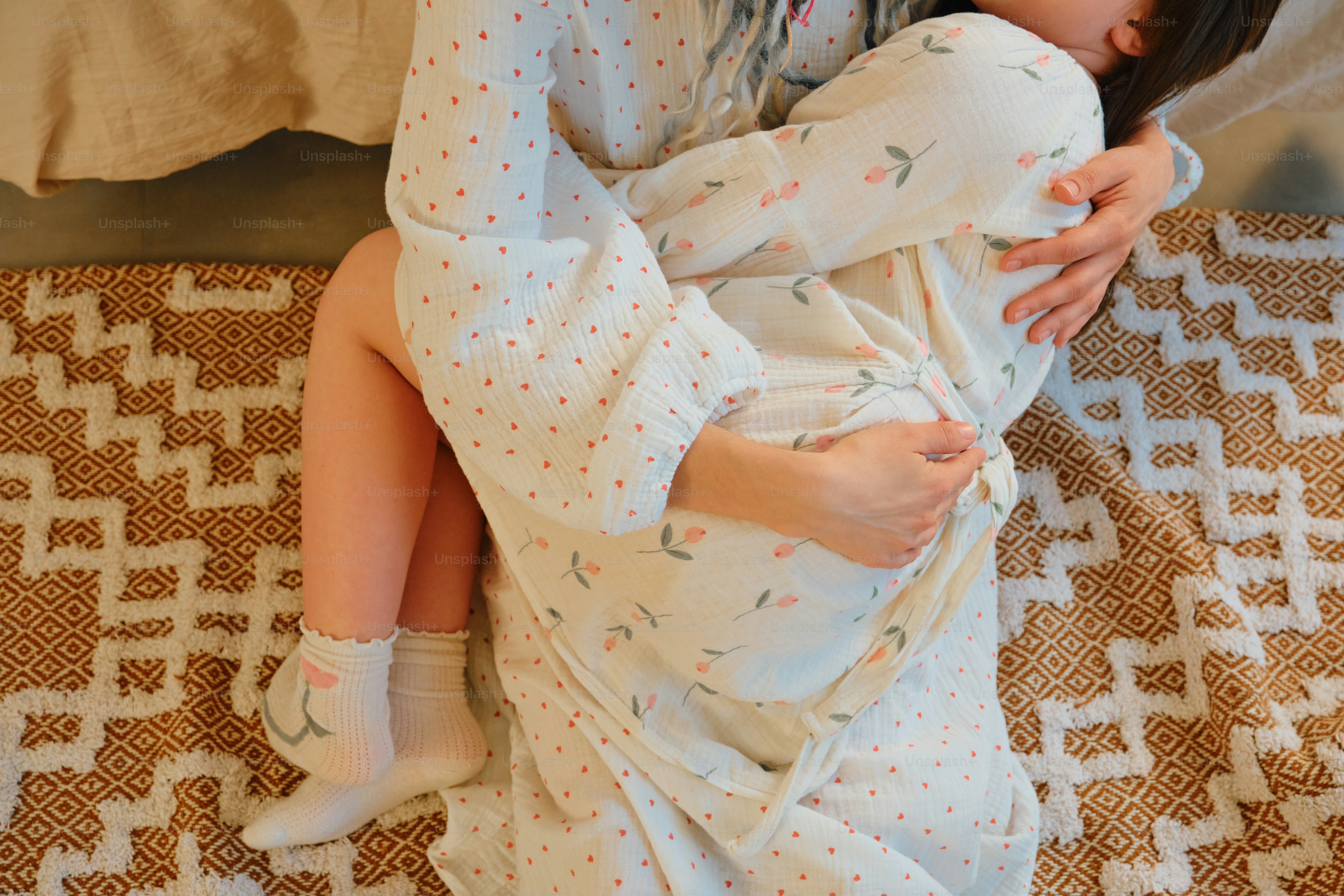 Mother holding sleeping child wrapped in blanket