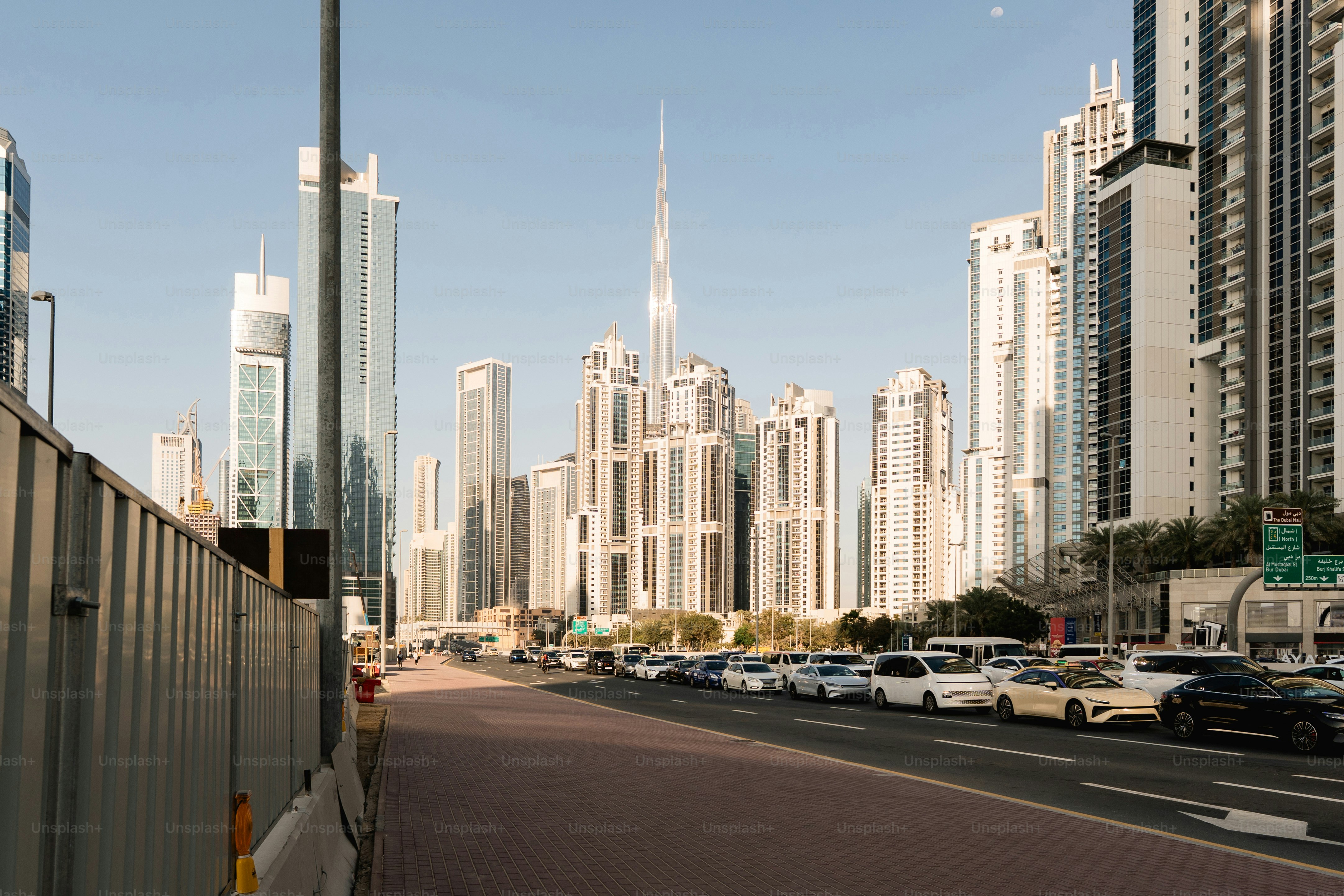 Moderne Wolkenkratzer säumen eine Straße mit geparkten Autos.