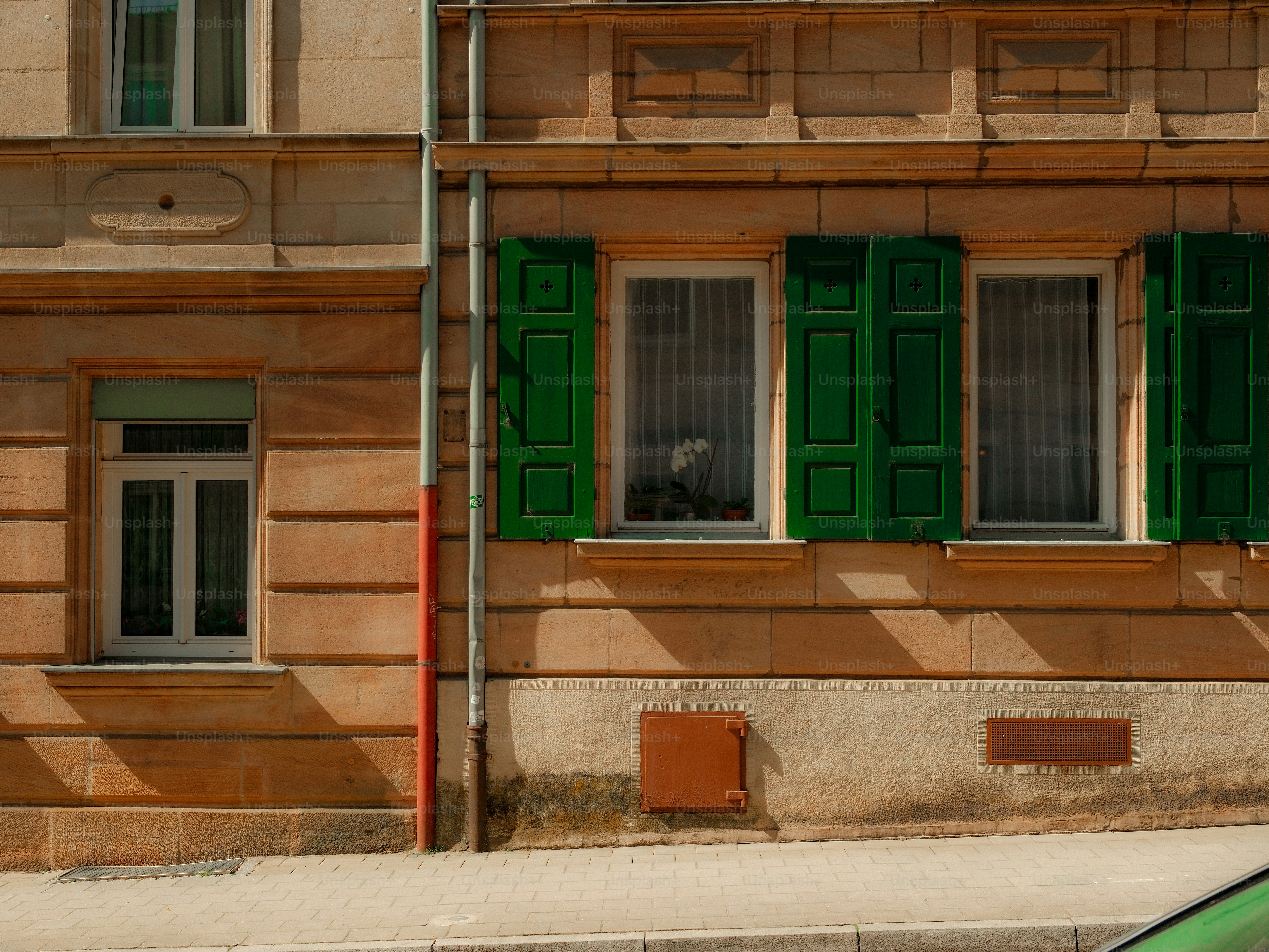 Fachada del edificio con contraventanas y ventanas verdes