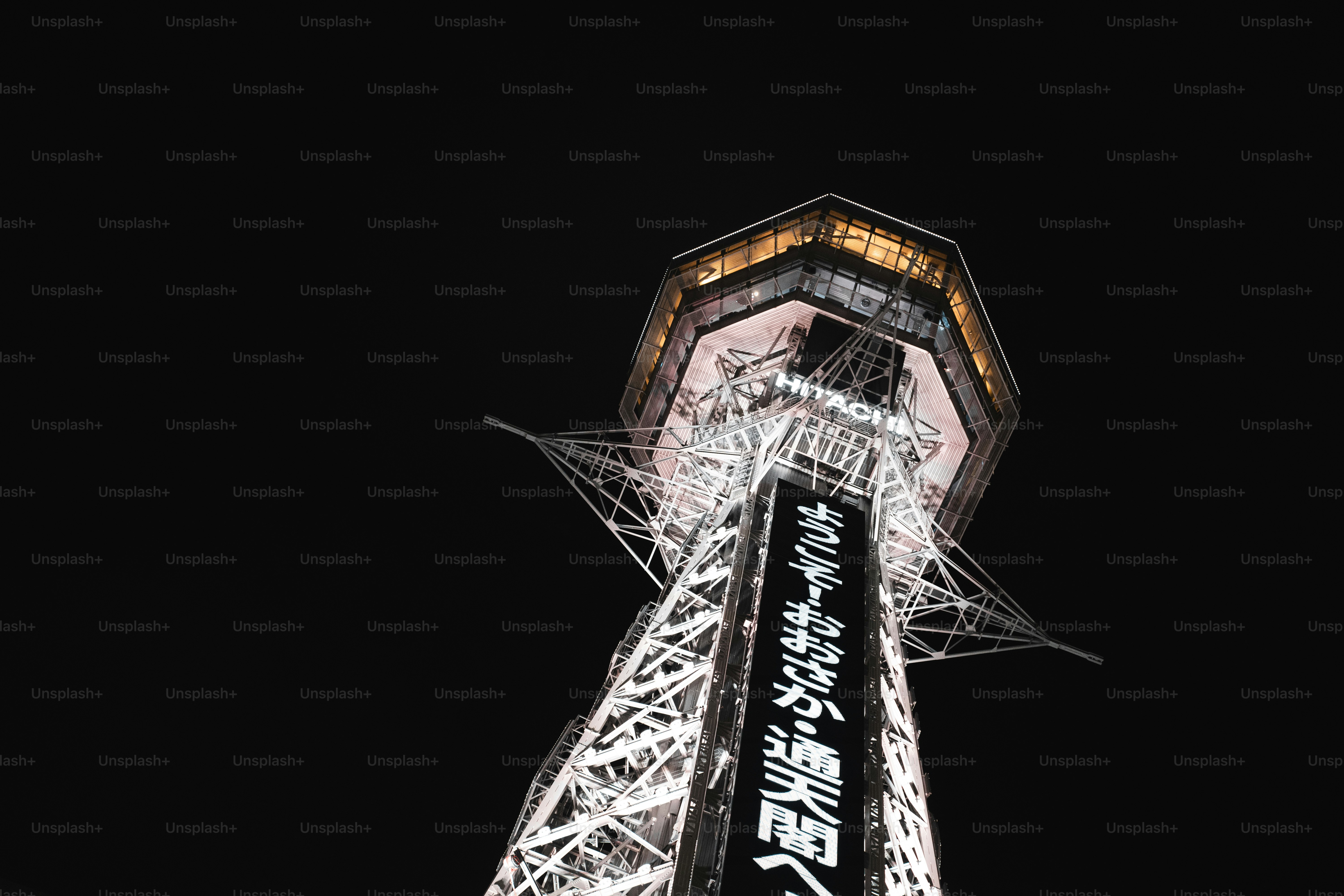 Tall tower illuminated at night with dark sky