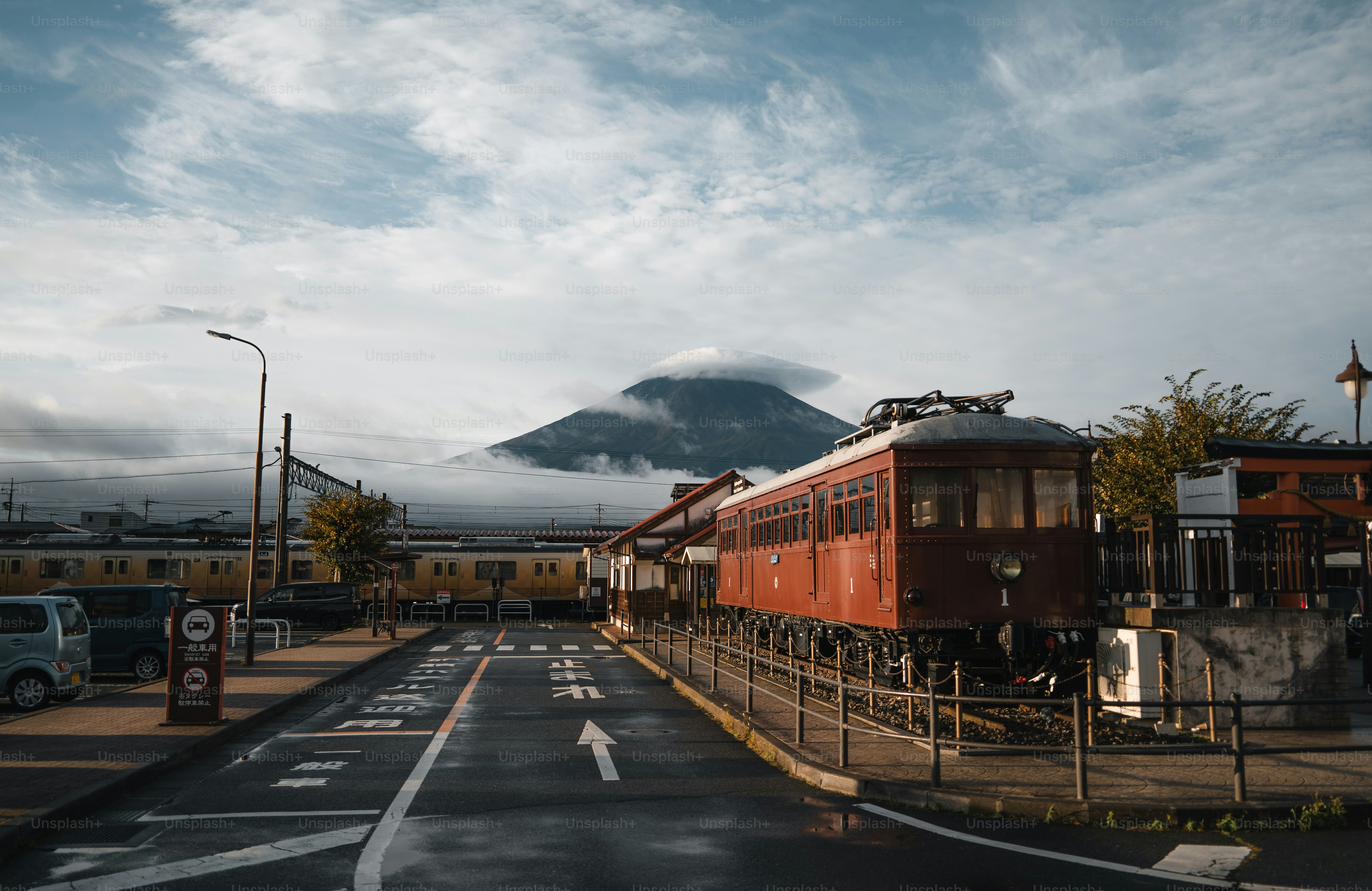 Red train car near mount fuji under cloudy sky