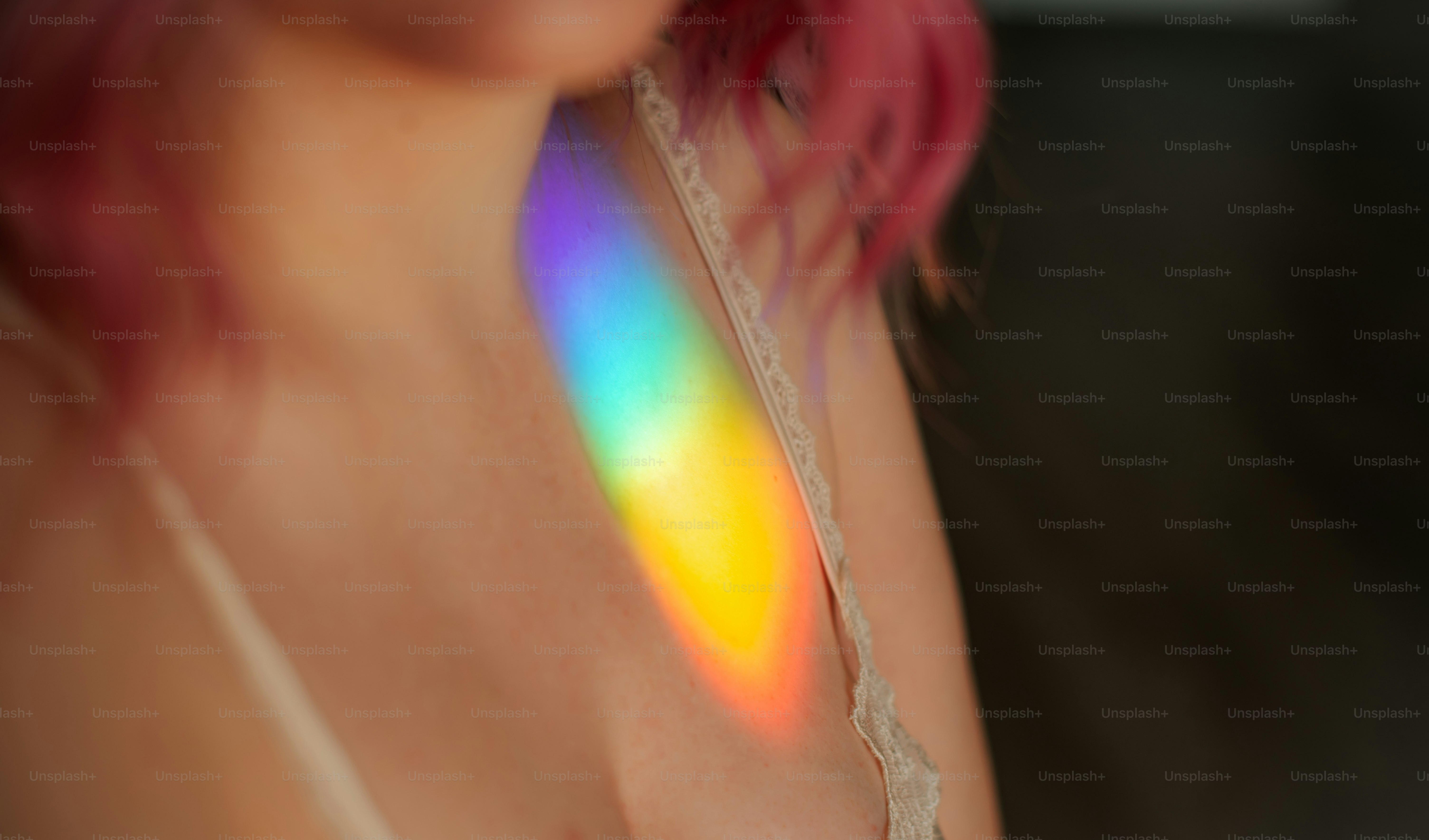 Wanita dengan rambut merah muda dan pantulan cahaya pelangi