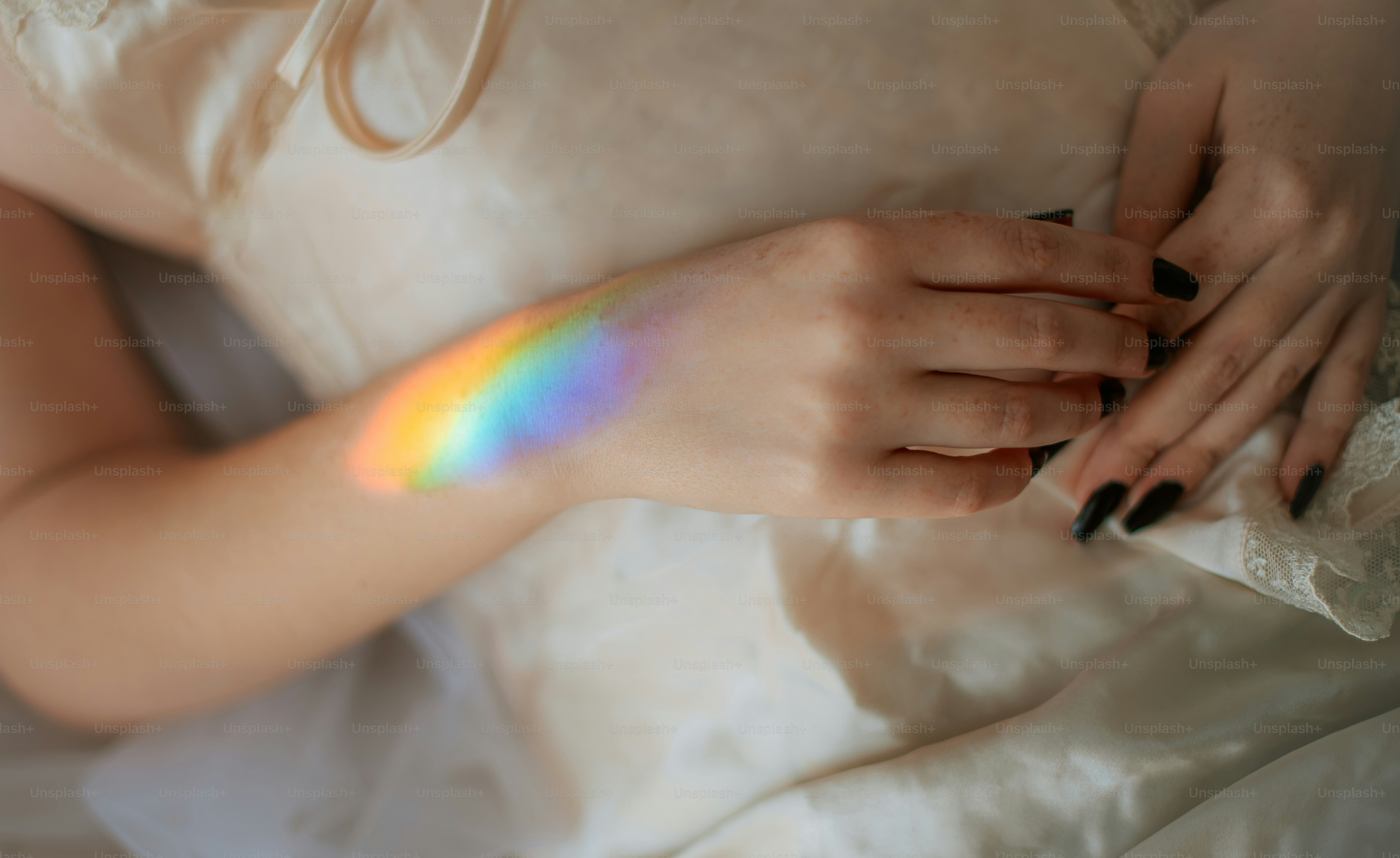 Lengan wanita dengan pantulan cahaya pelangi