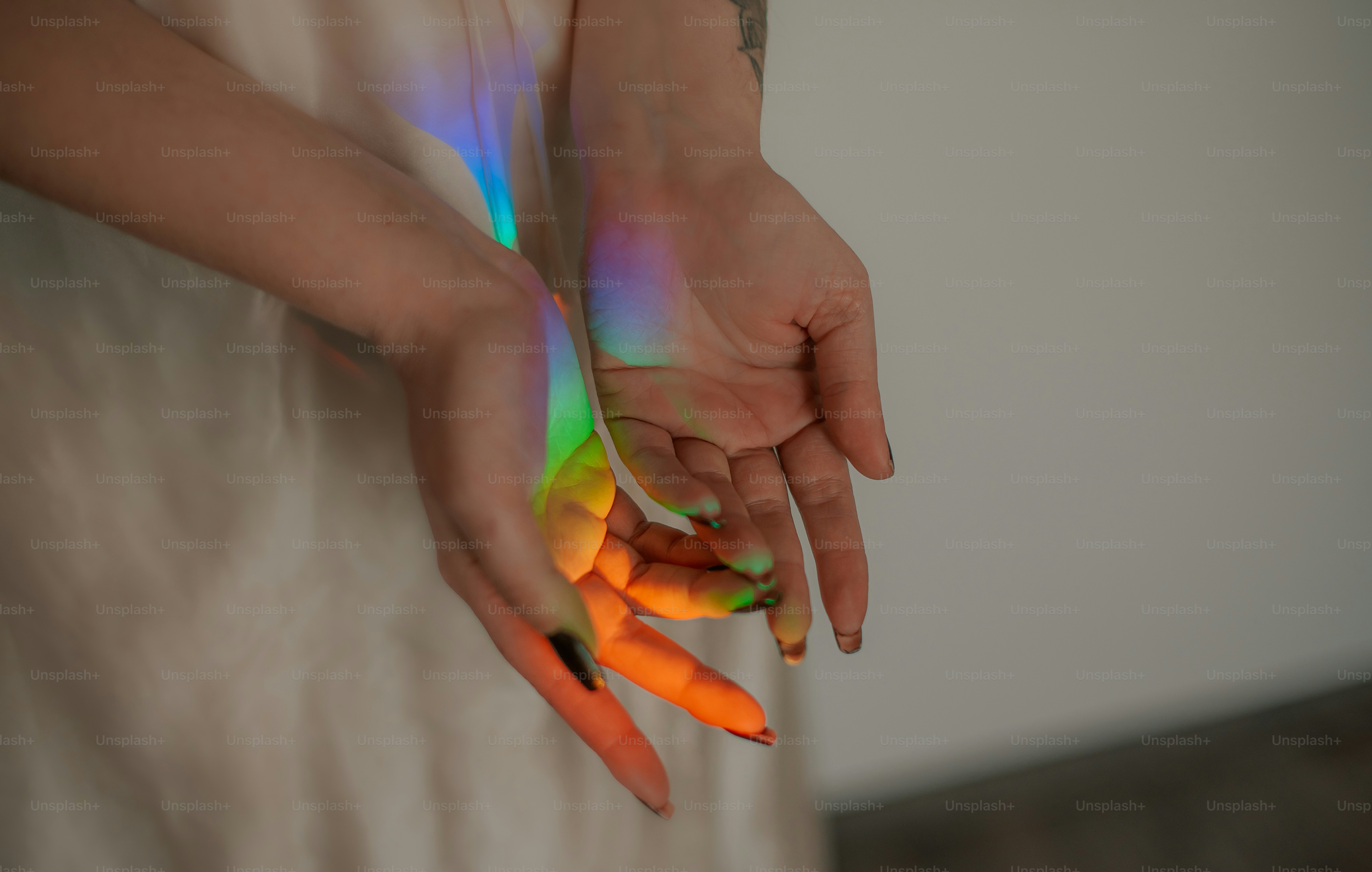 Tangan diterangi oleh spektrum cahaya warna-warni