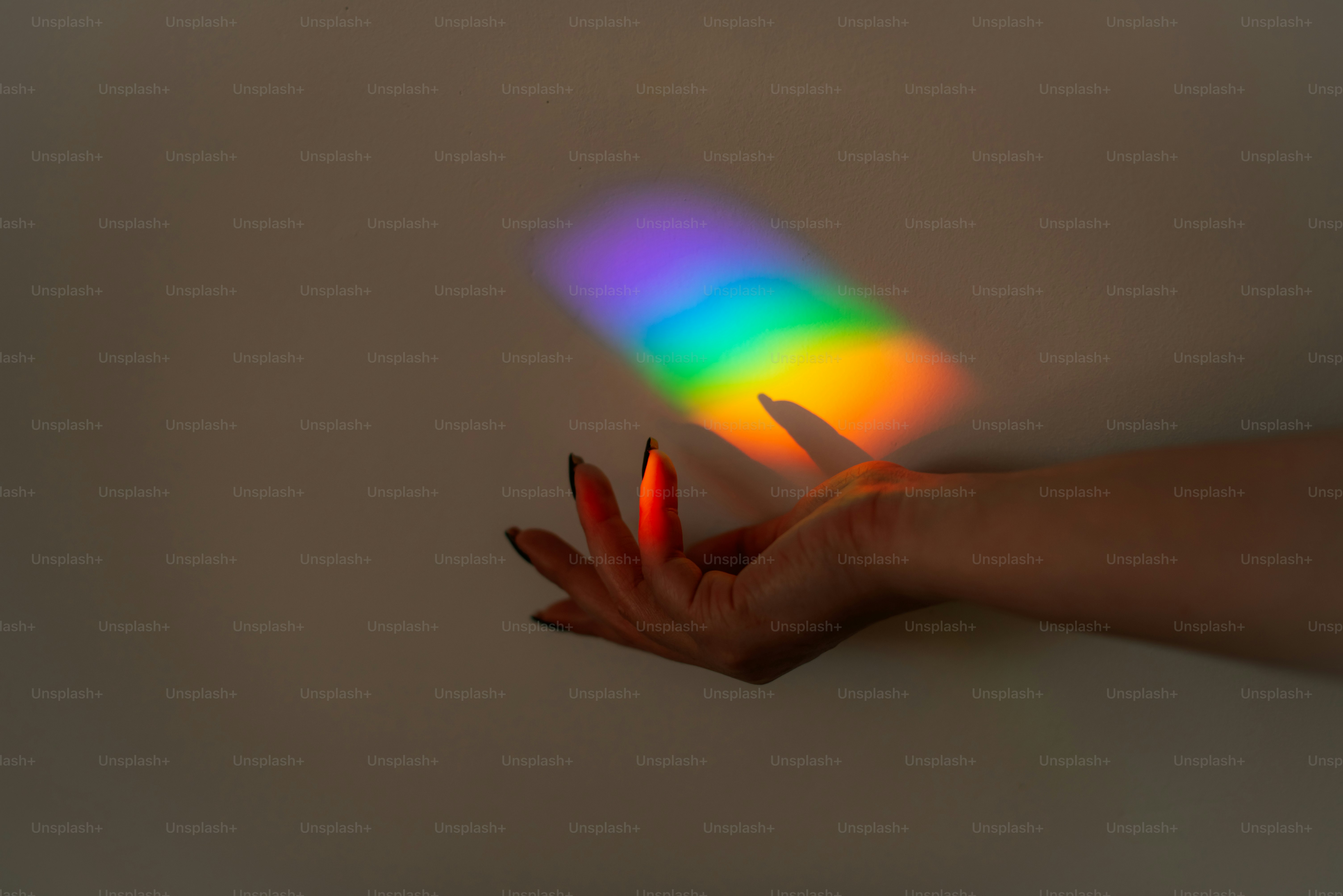 Cahaya pelangi memancarkan cahaya warna-warni di tangan.