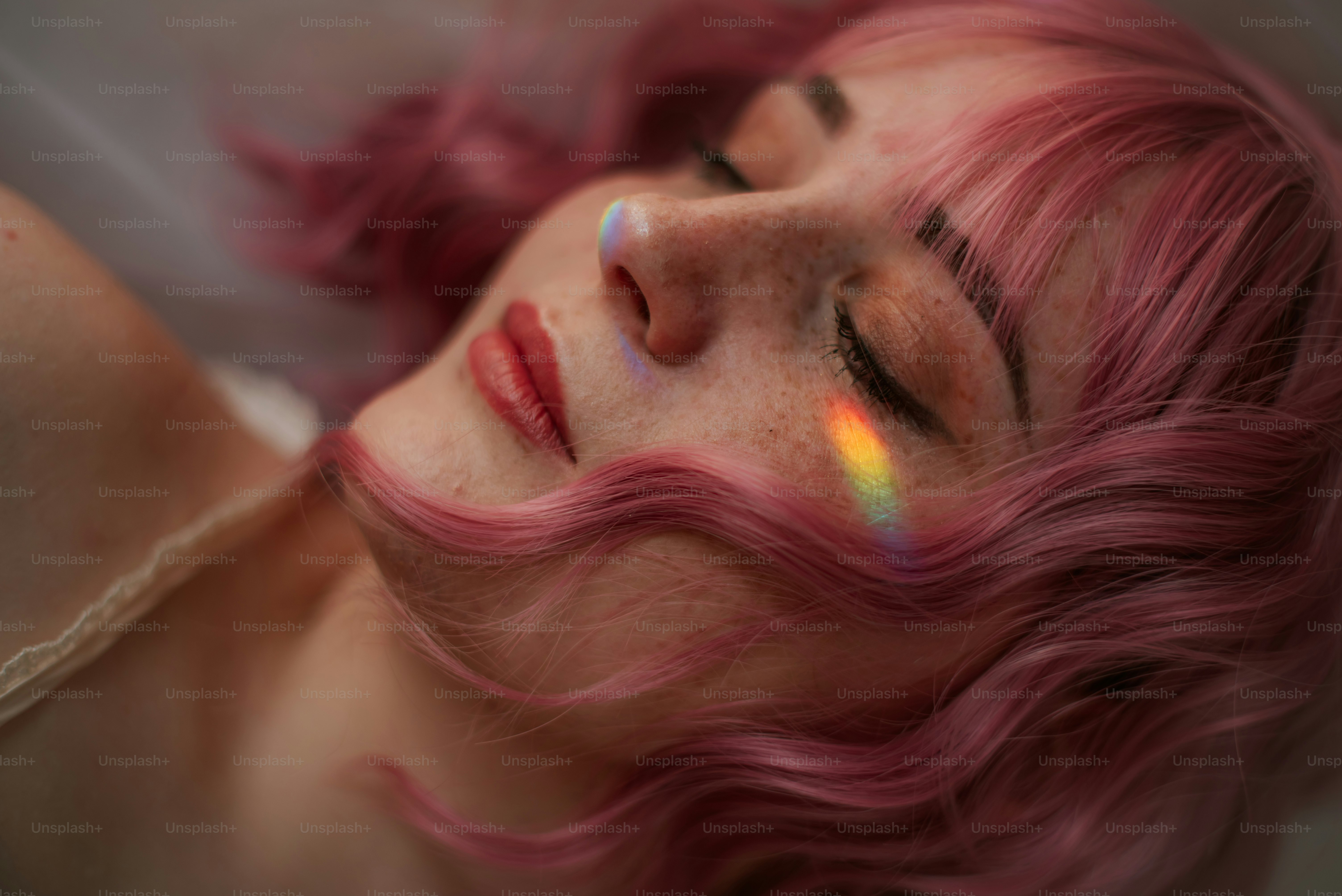 Wanita dengan rambut merah muda dan cahaya pelangi di wajah