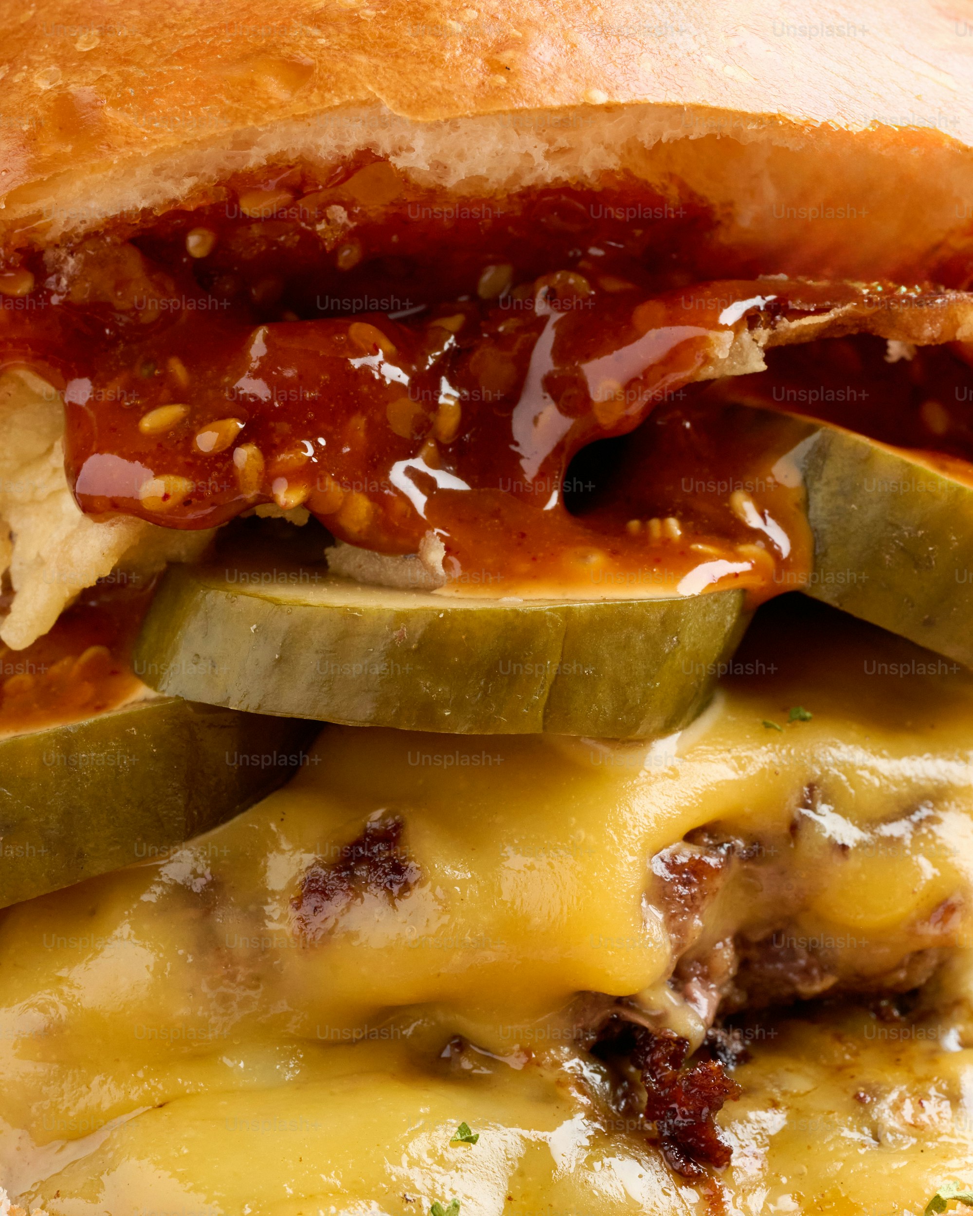Um close de um cheeseburger suculento com picles e molho