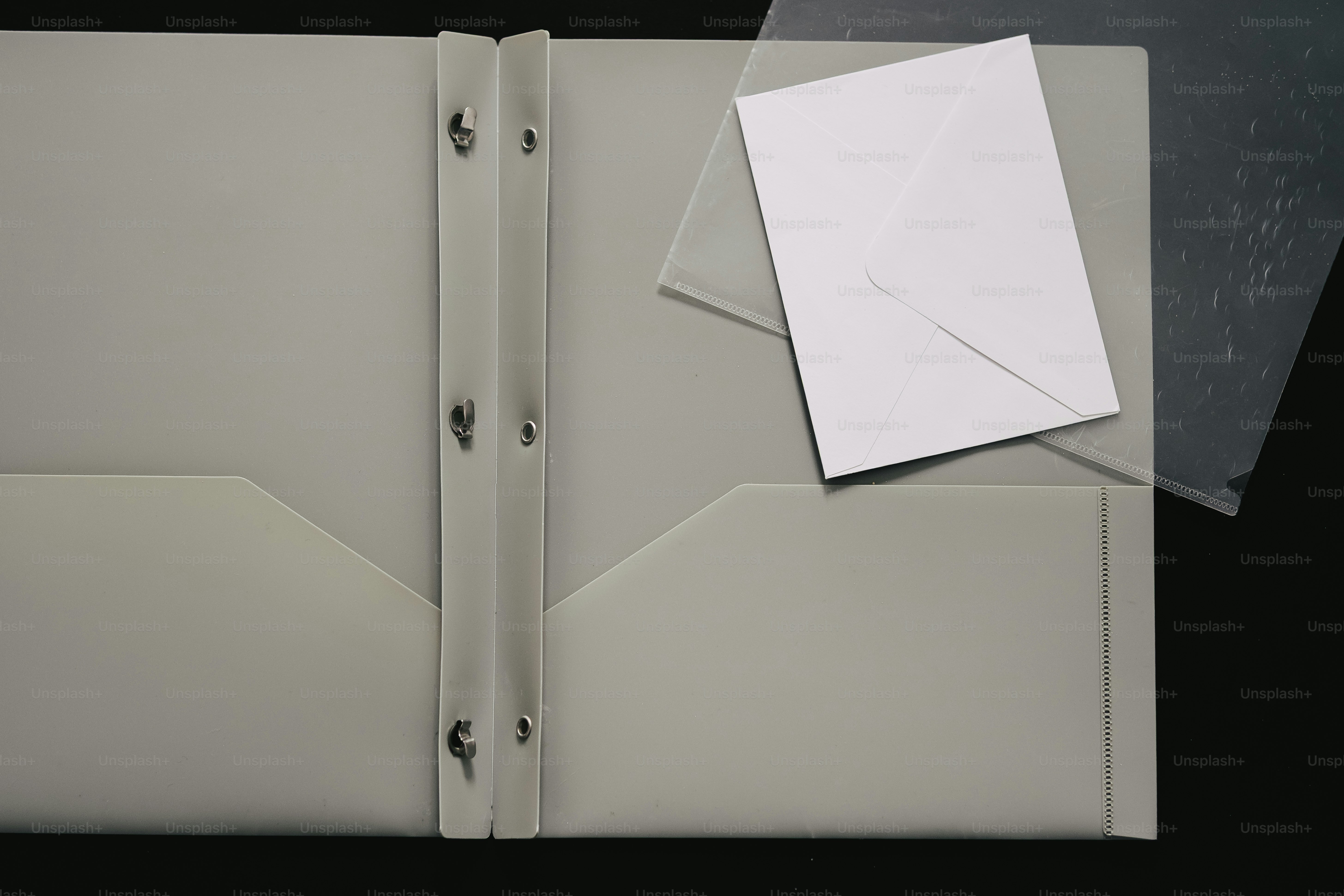 연한 회색 폴더 안에 담긴 흰 봉투.