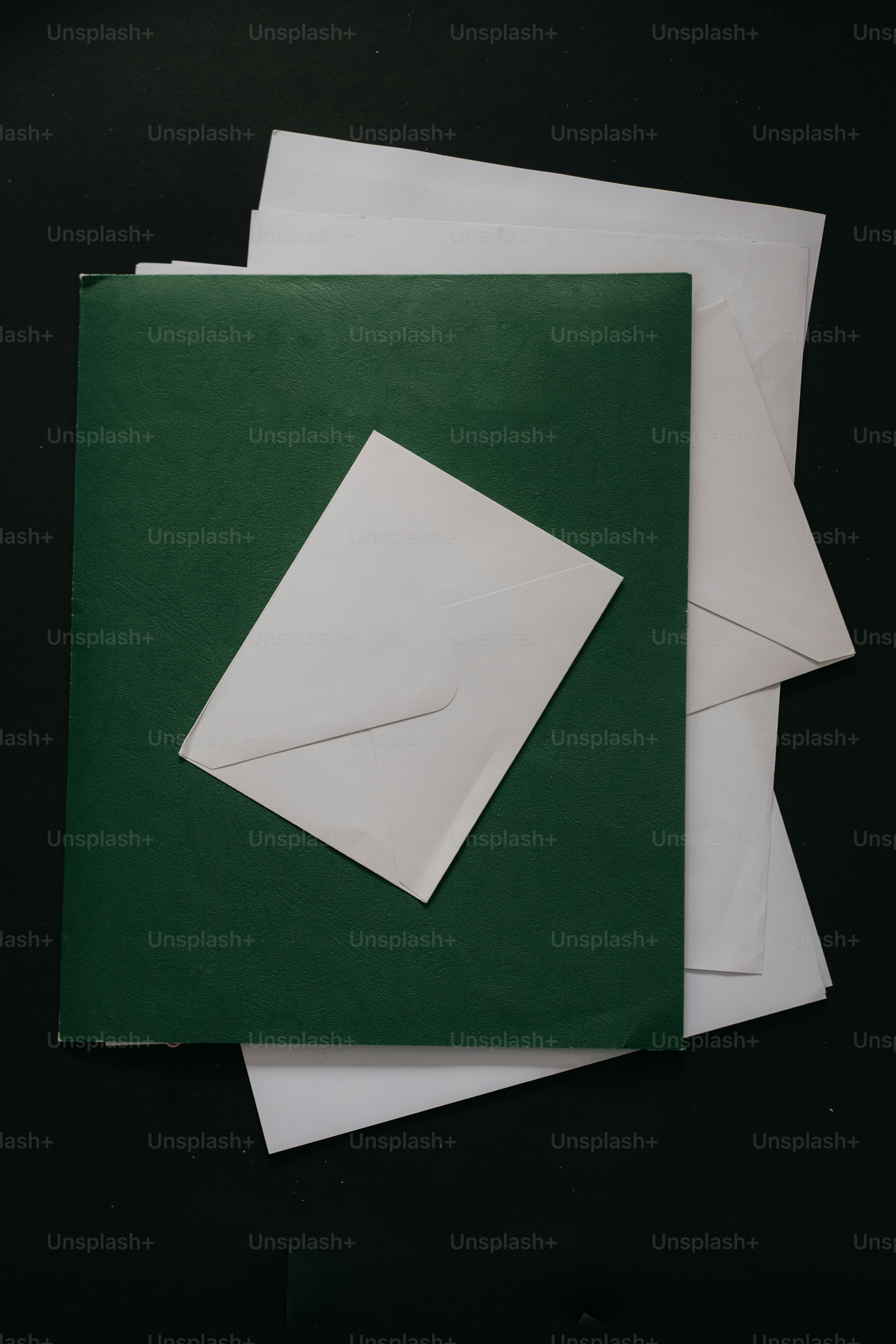 어두운 배경에 흰색 봉투가 있는 초록색 폴더