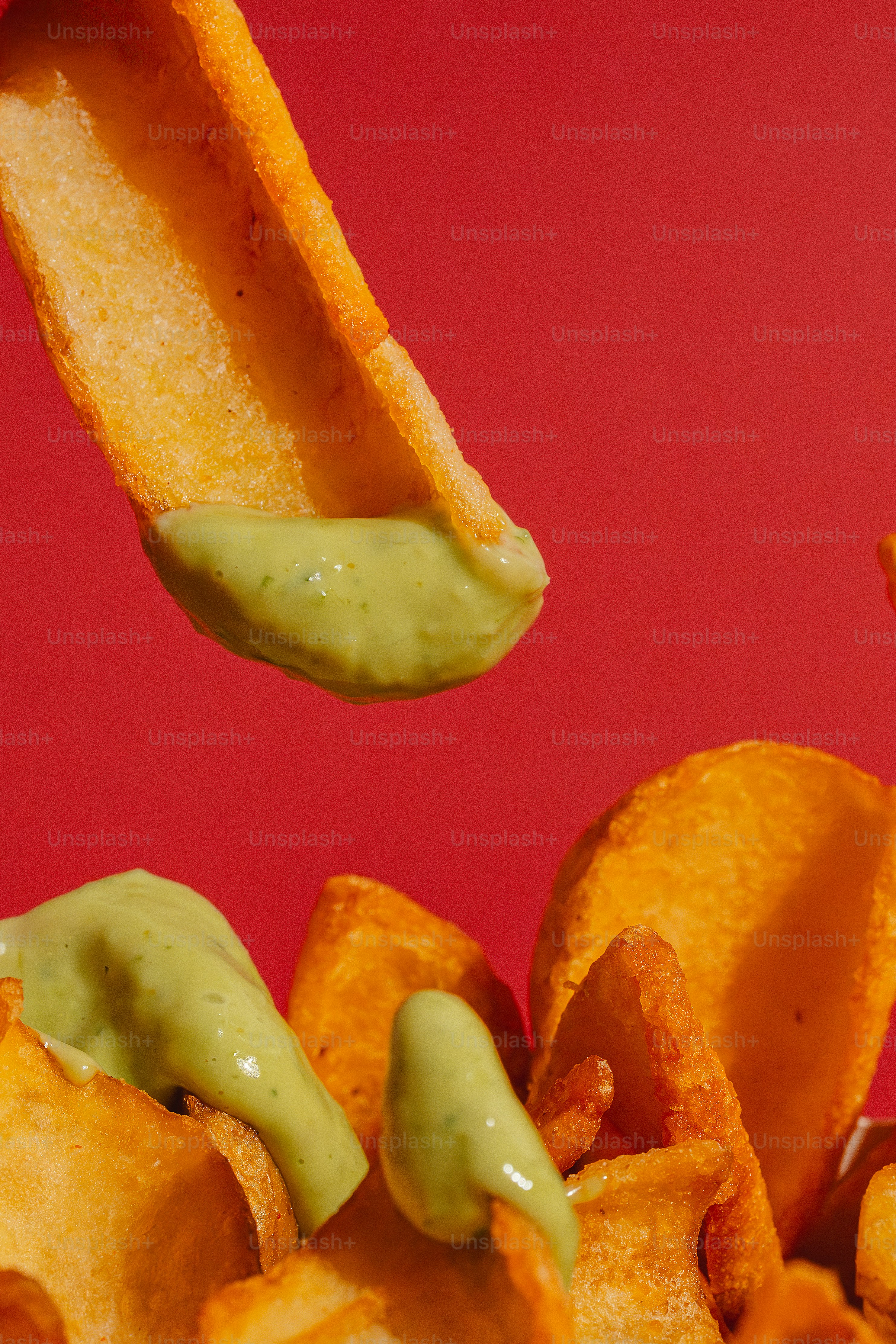 A potato wedge is dipped in green sauce photo – Fast food Image on Unsplash