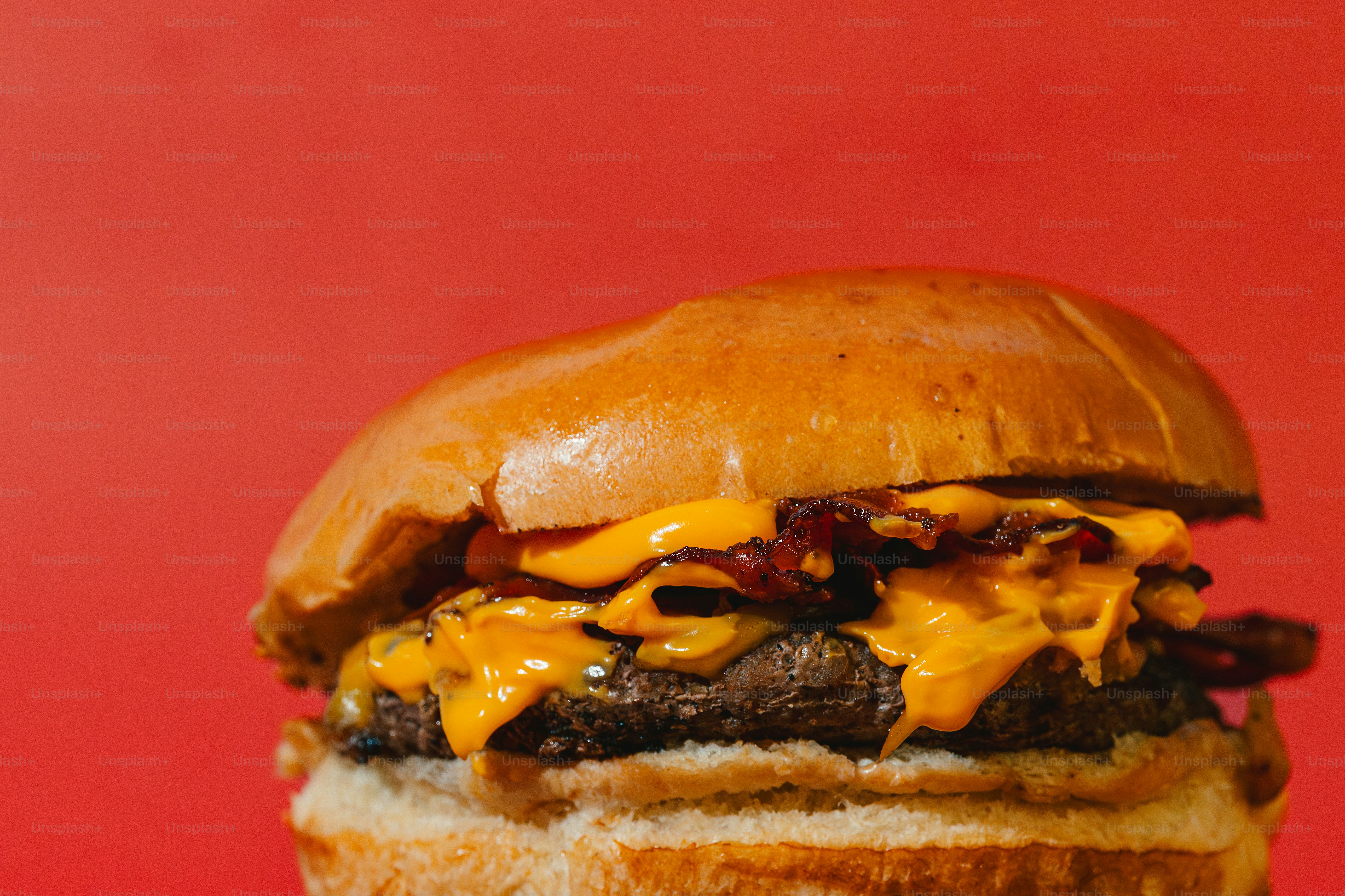 A delicious bacon cheeseburger on a red background