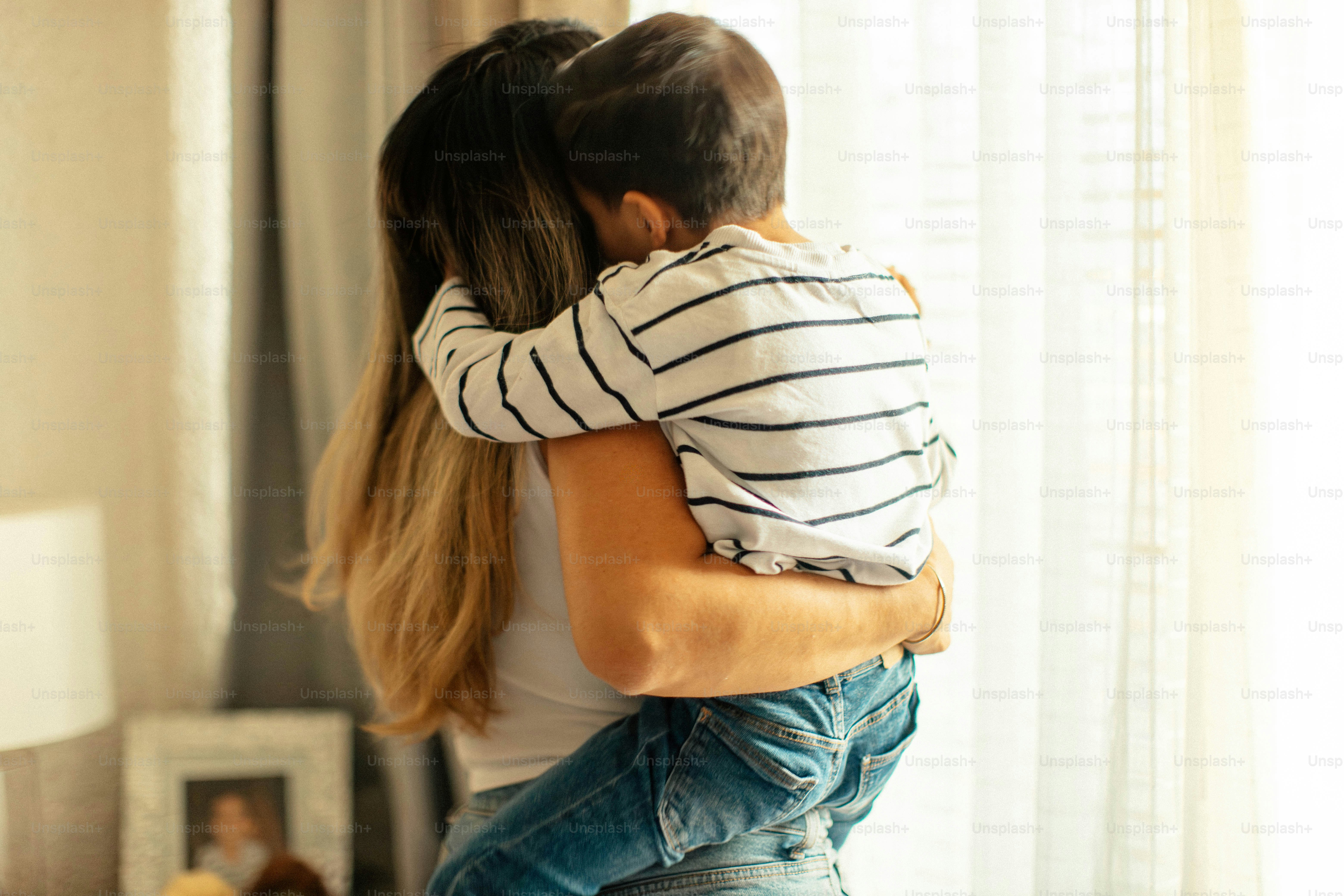 A mother hugs her young son tightly.