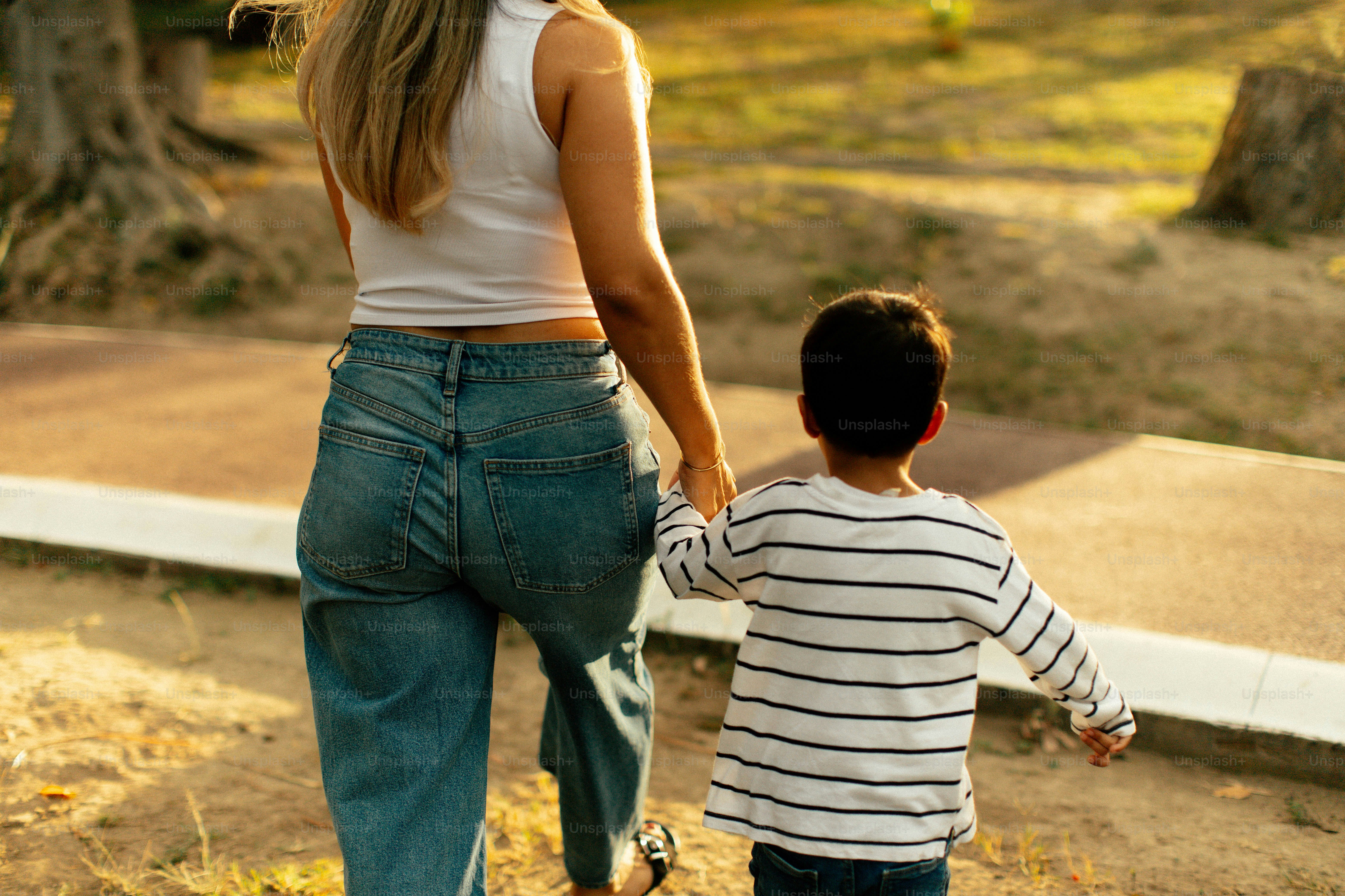 Woman and child holding hands walking outdoors