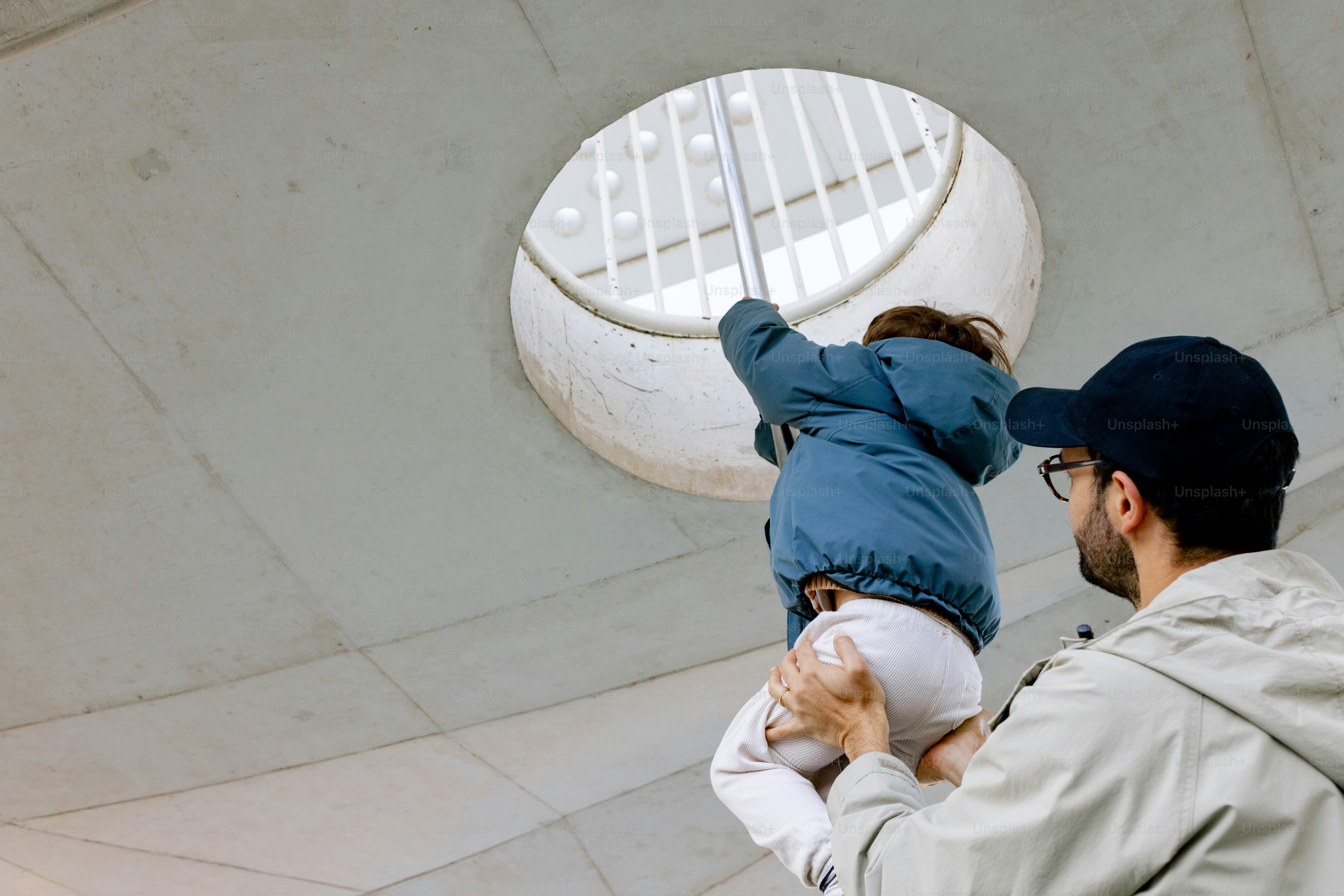 Ayah mengangkat anak menuju bukaan melingkar