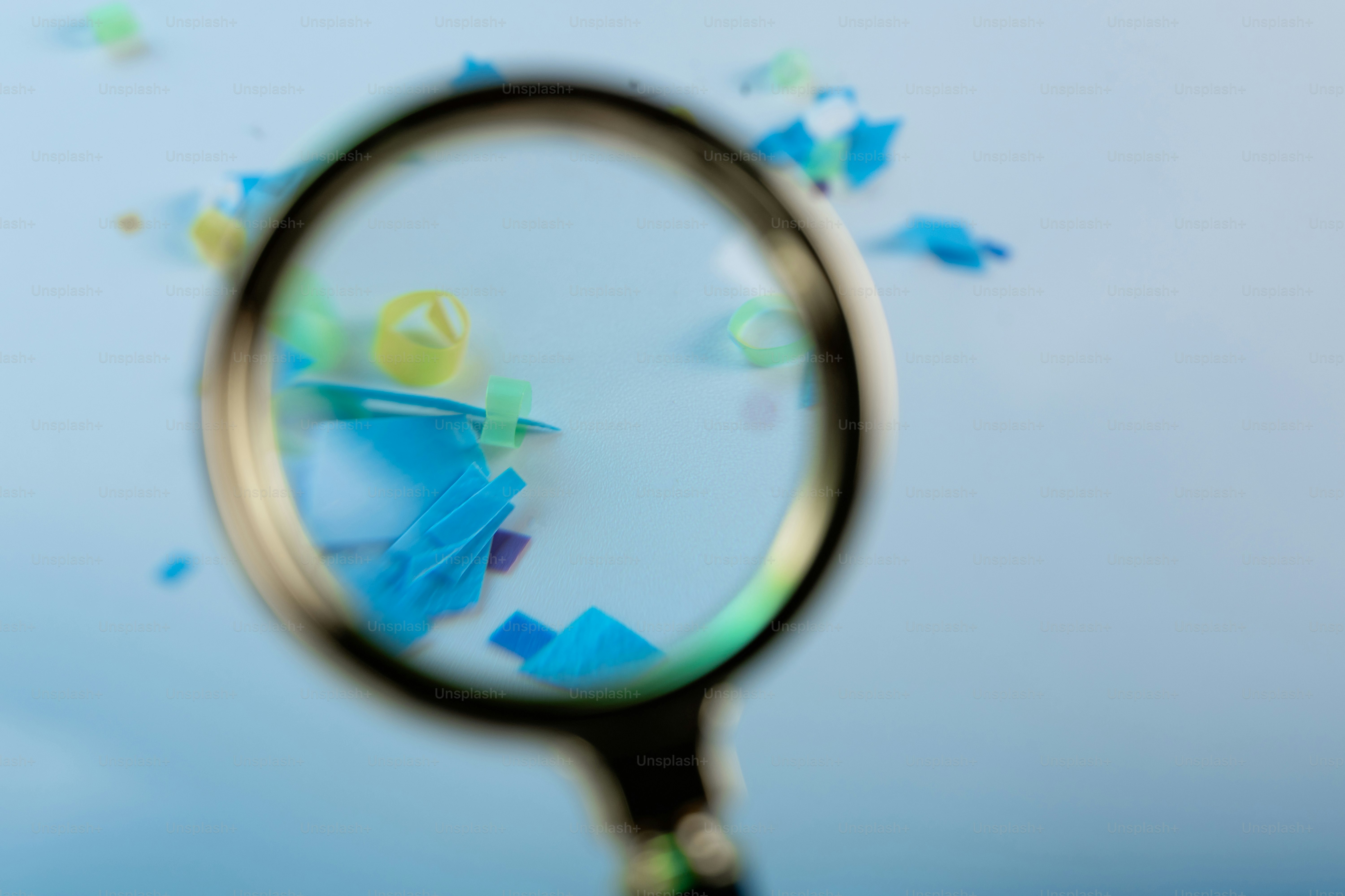 Magnifying glass over colorful small plastic pieces
