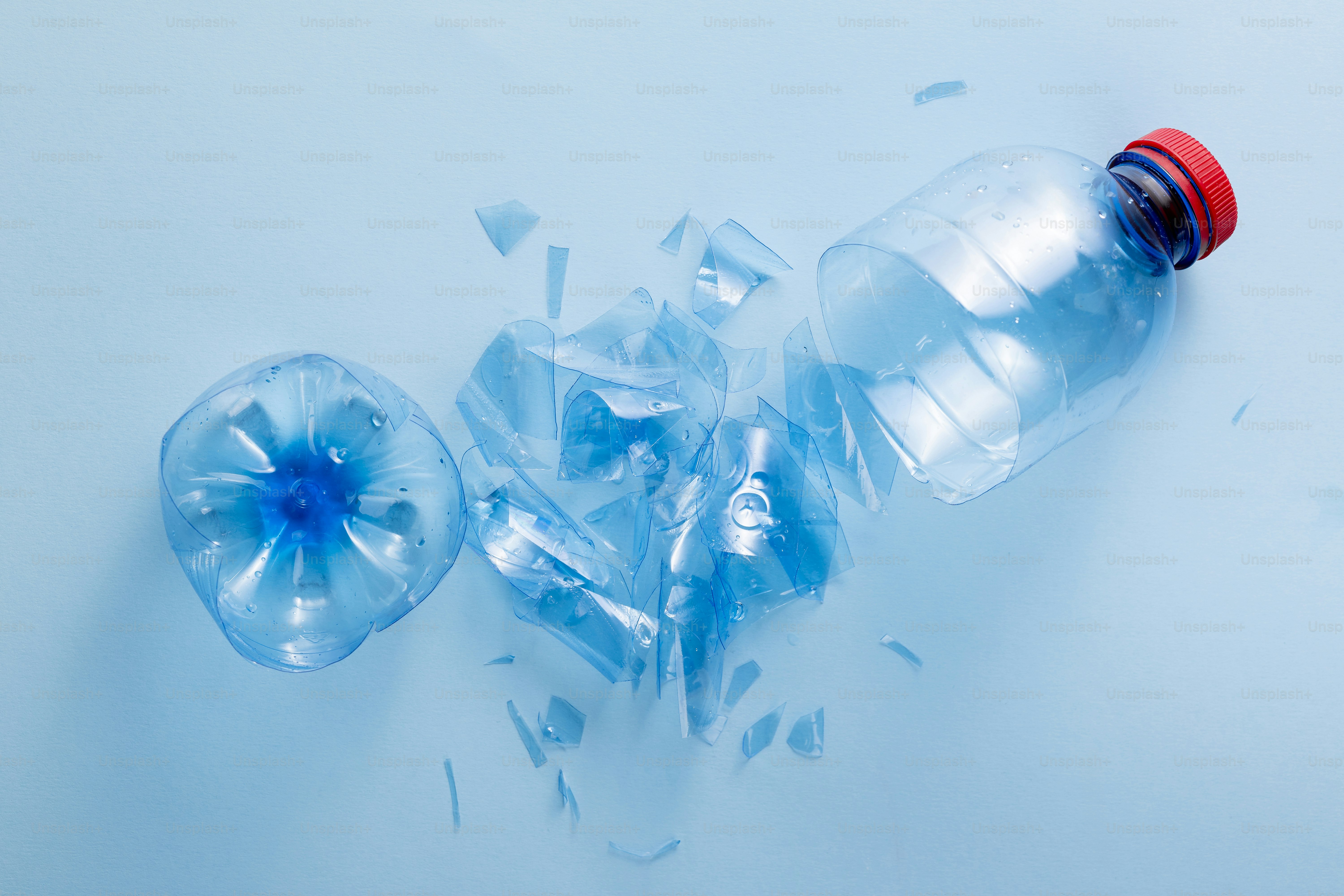 A shattered plastic water bottle on a blue surface photo – Laboratory ...