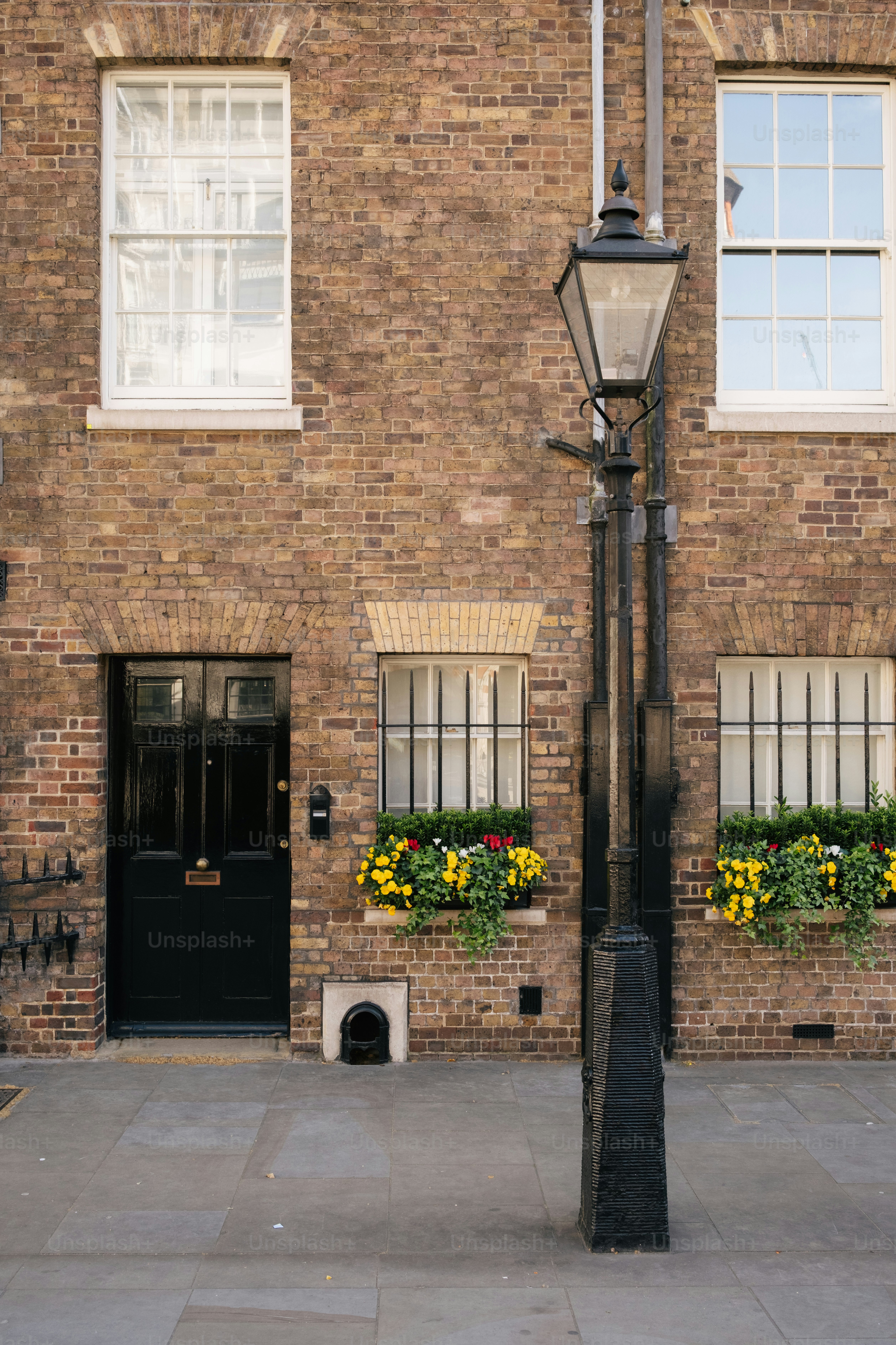 Old brick building with a black door and lamp