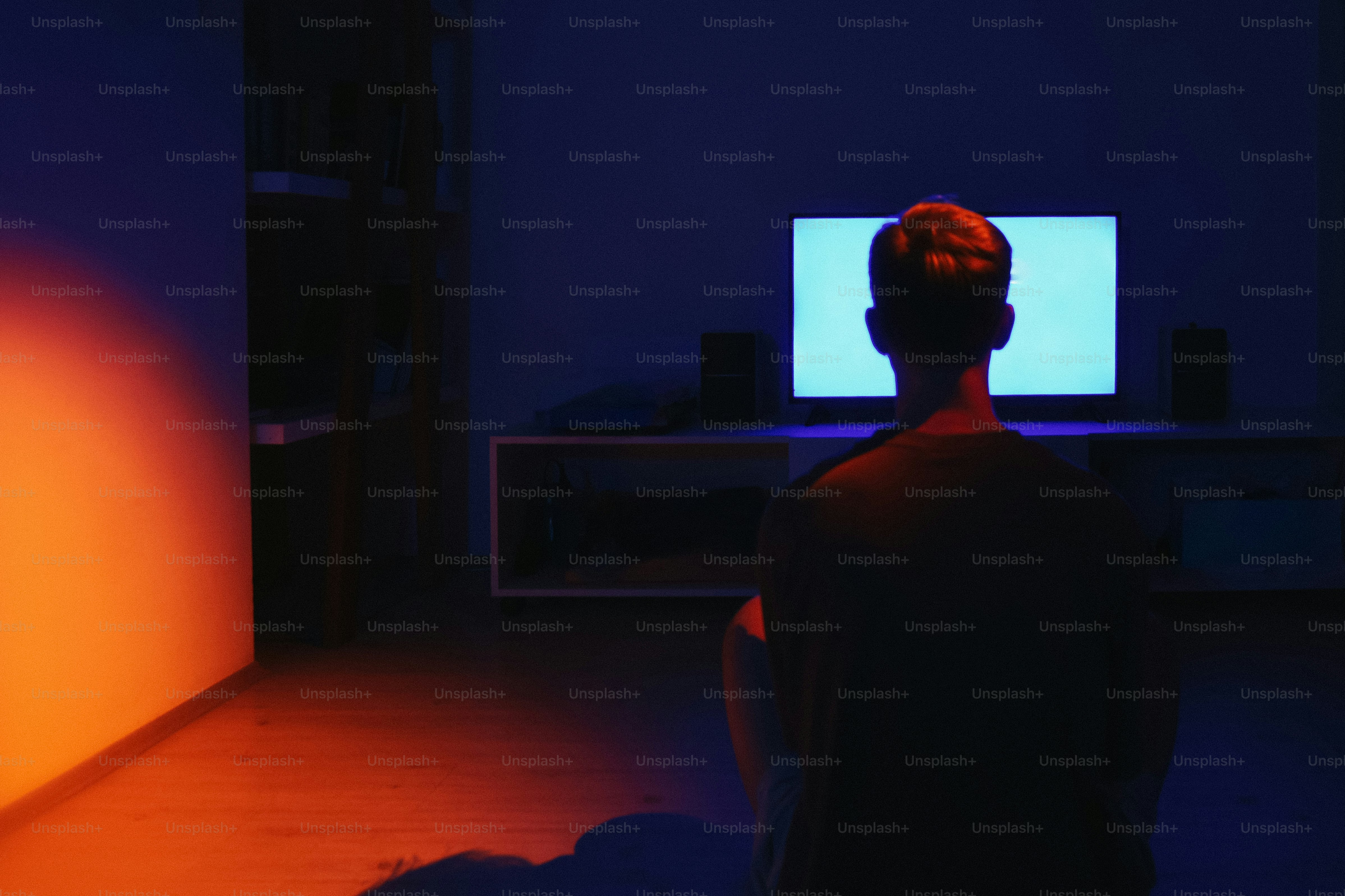 Person watching a bright screen in a dark room. photo – Night Image on ...