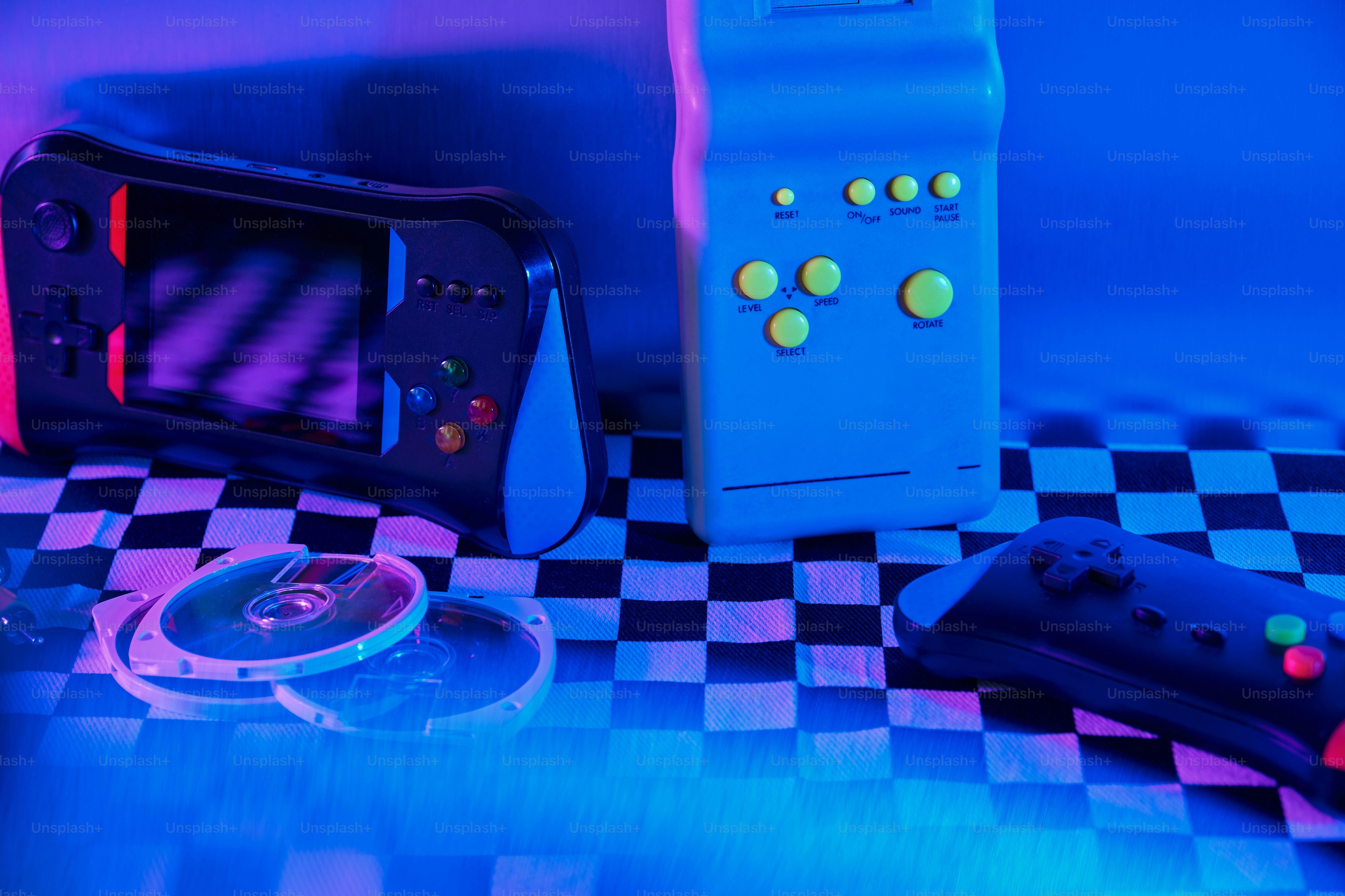 Retro gaming consoles and controllers on checkered surface photo ...