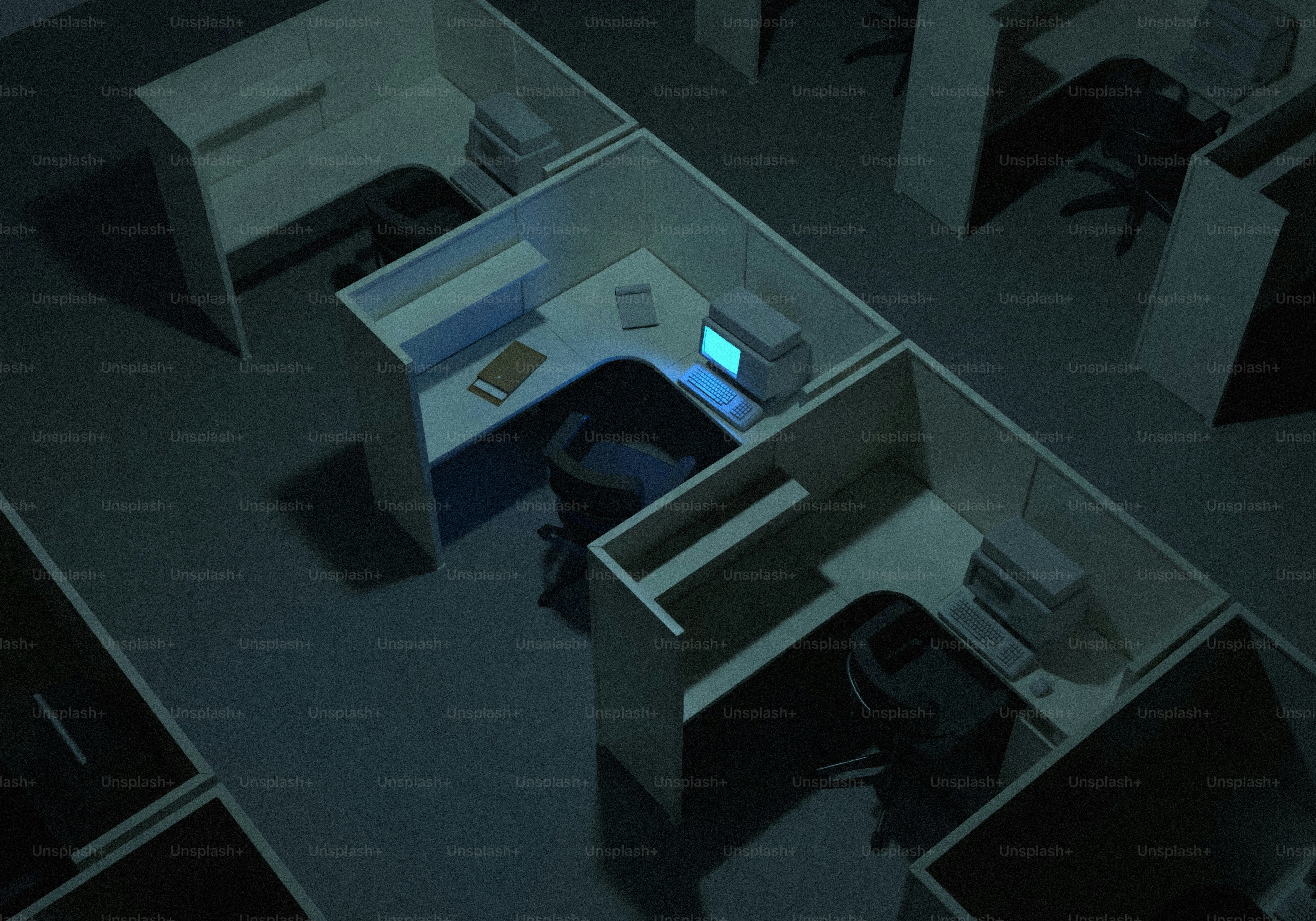 밤에는 빈 사무실 칸막이 공간에 한 대의 컴퓨터 화면이 켜져 있습니다.