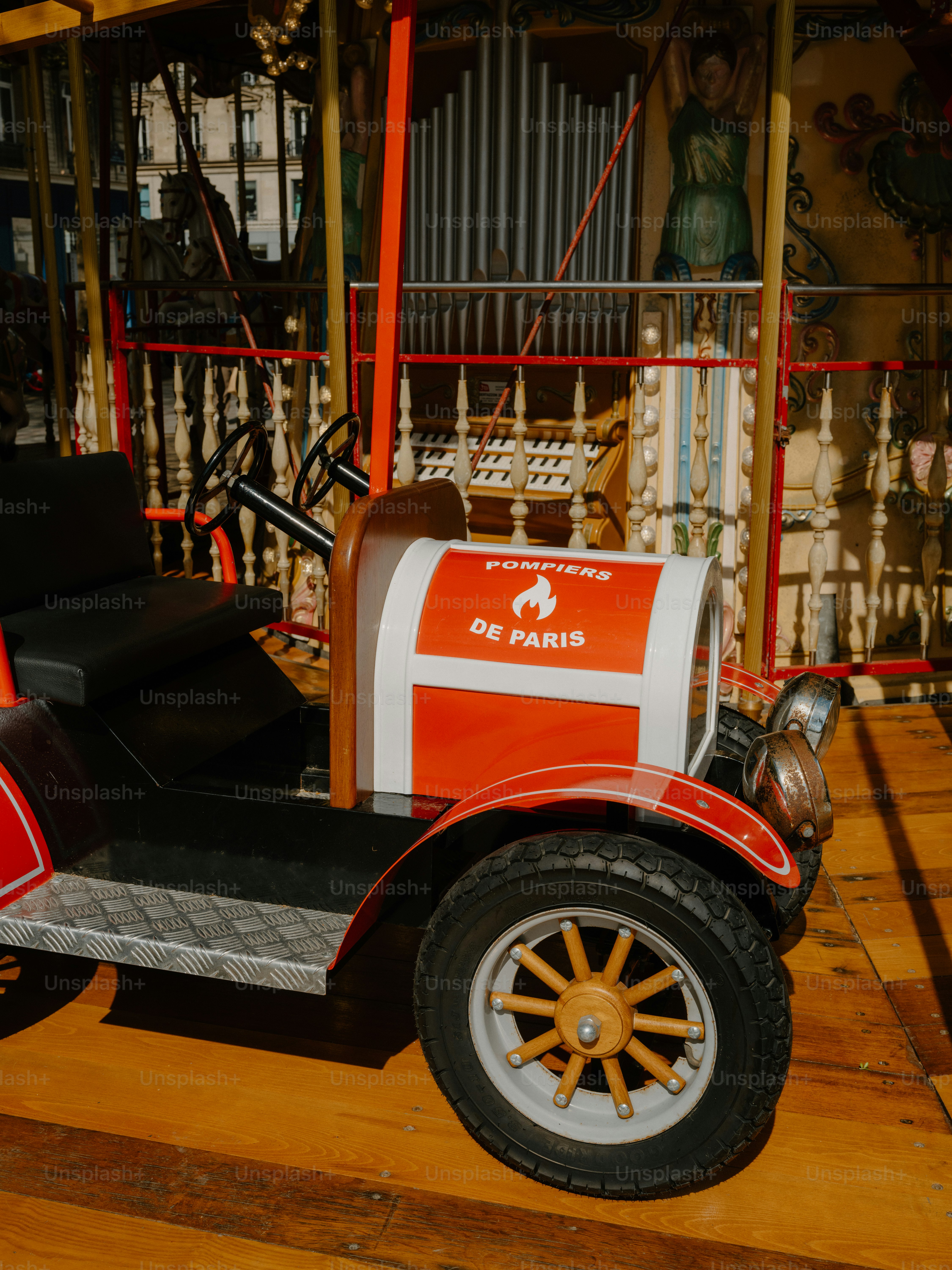 A vintage red fire truck on a carousel.
