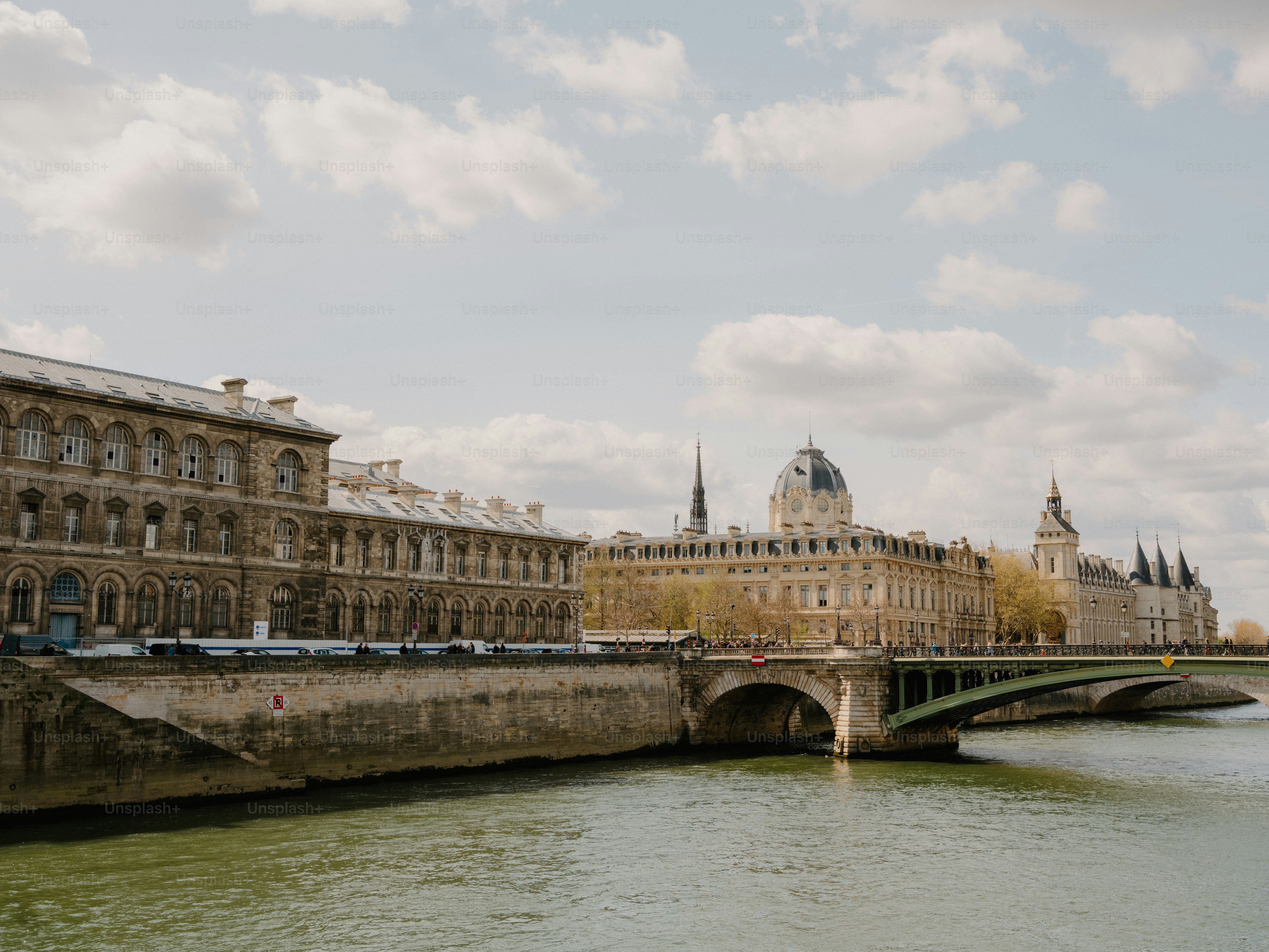 Historic buildings line a river with a bridge. photo – Building Image ...